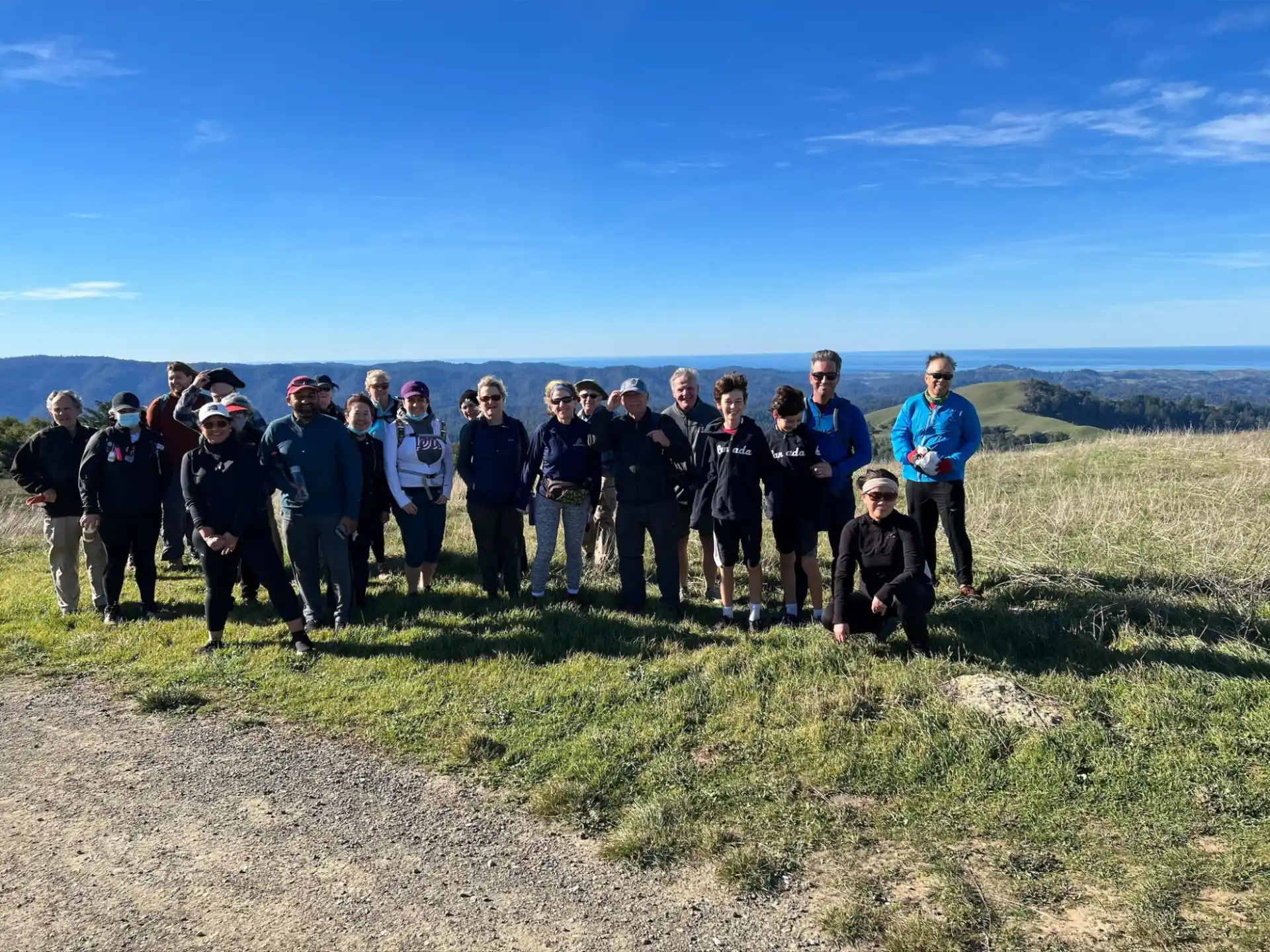 a group of people posing for a photo on a hill
