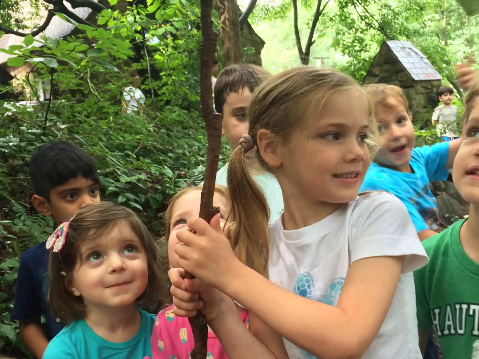 a group of children holding a snake