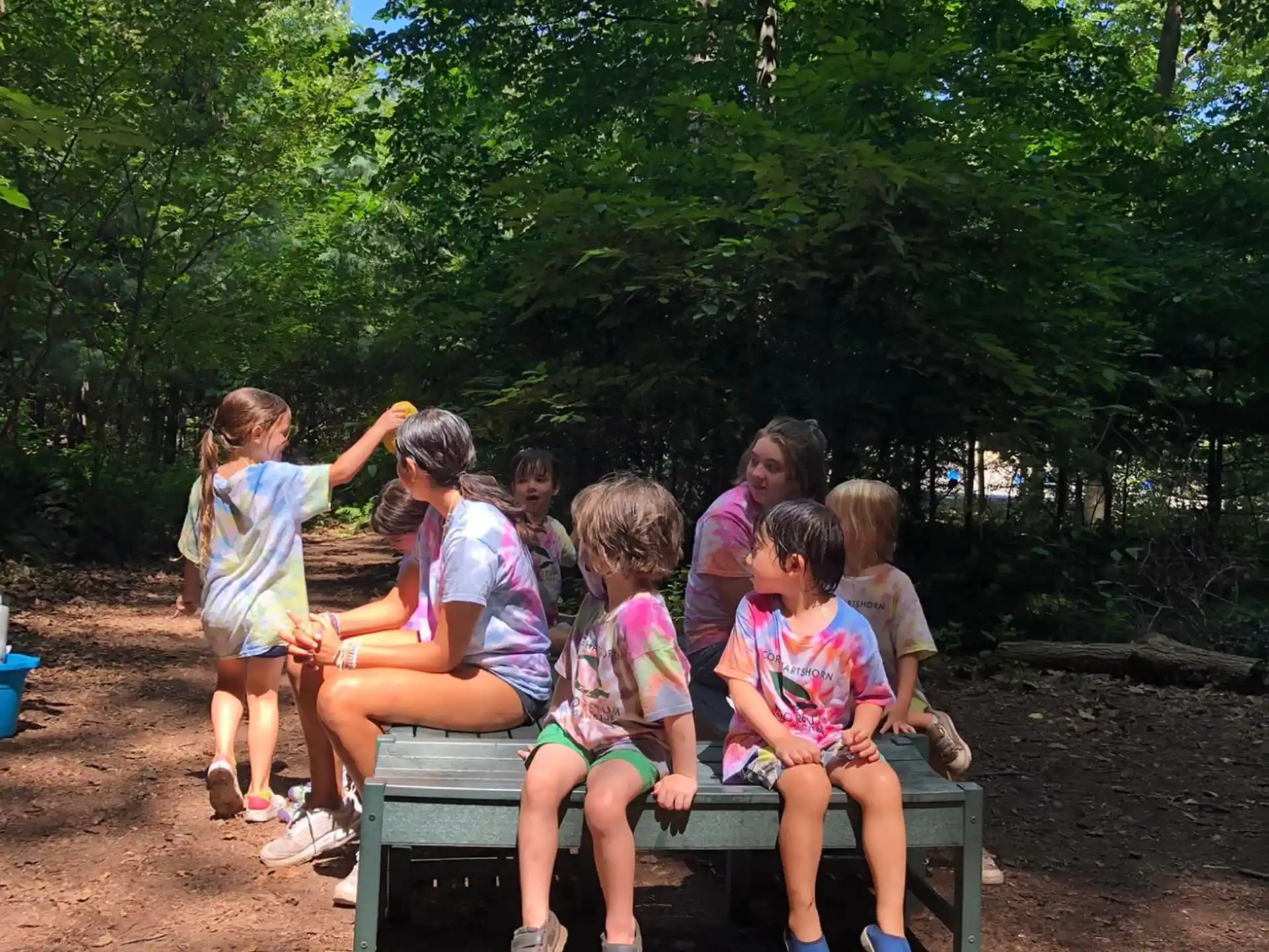 a group of children sitting on a bench in a park