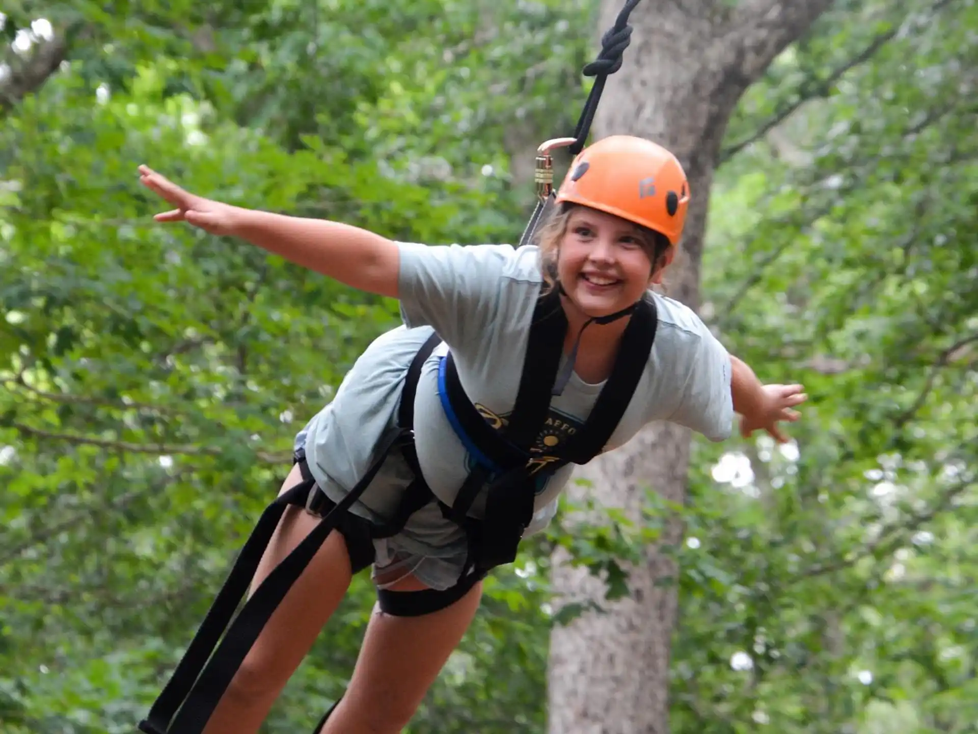 a person wearing a helmet and climbing a tree
