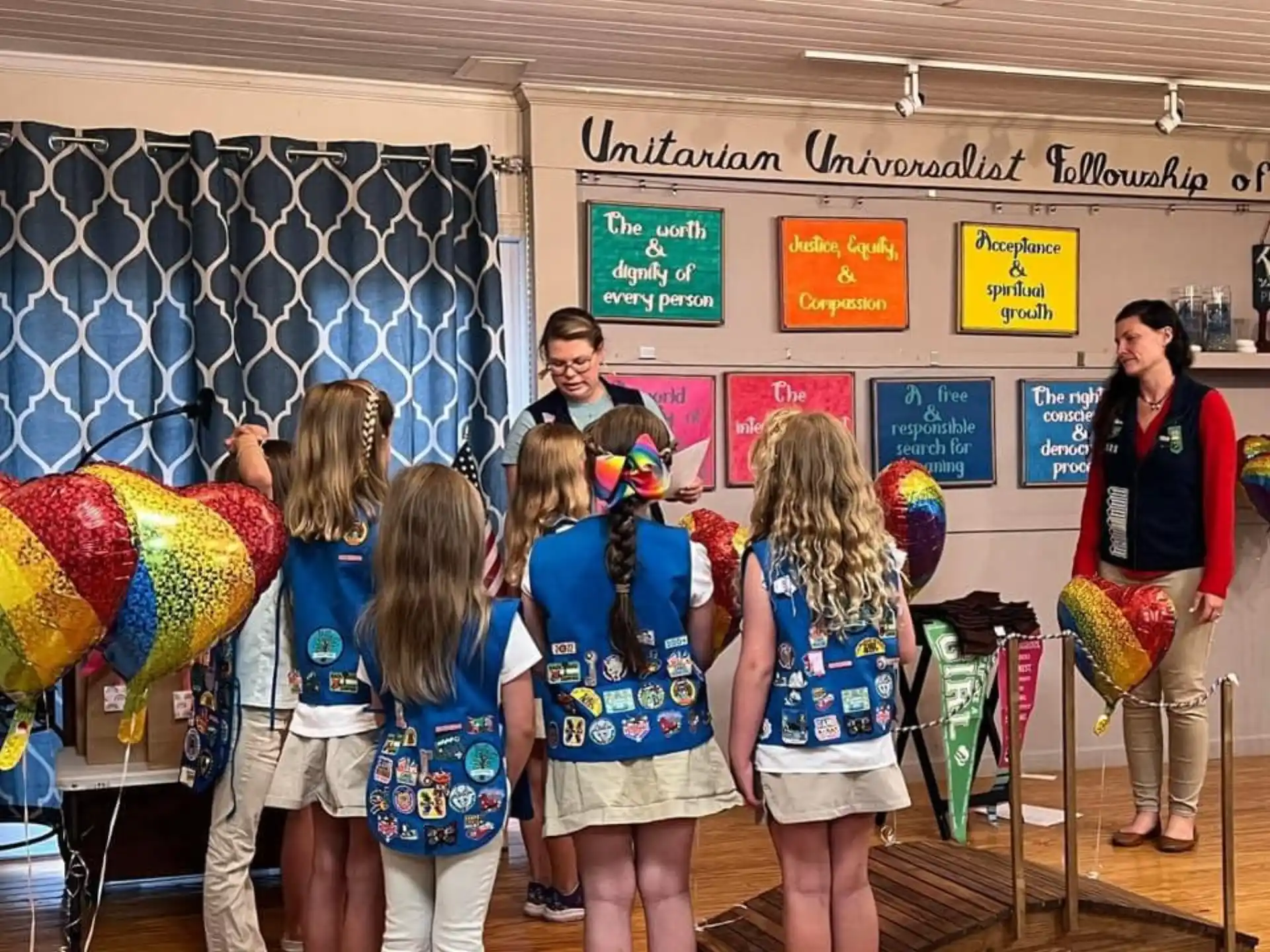 a group of people standing in front of a person in a garment