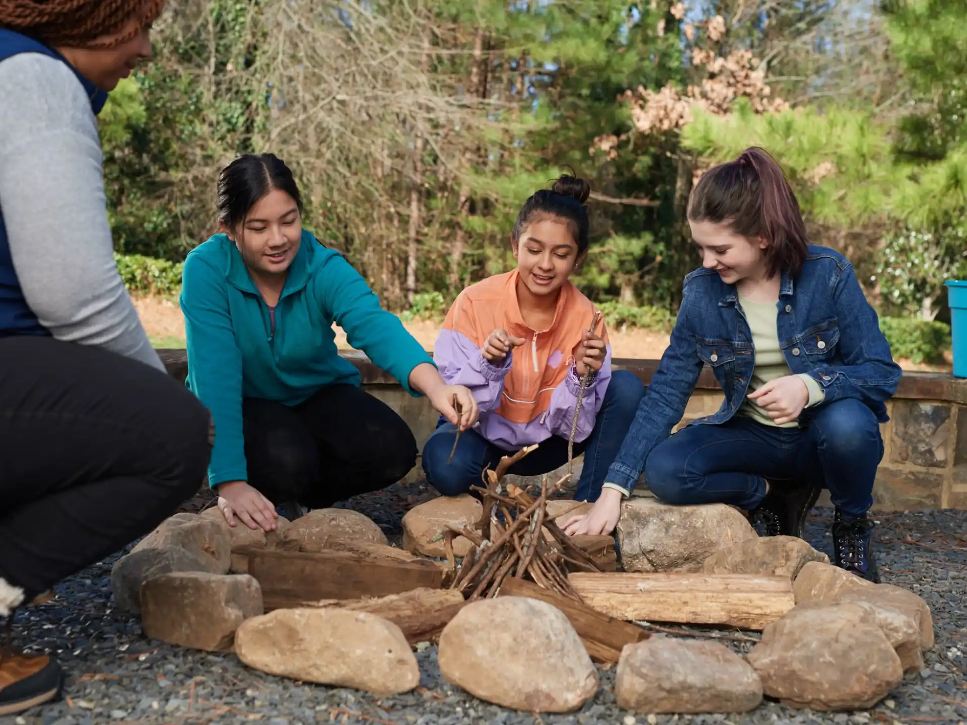 a group of women sitting around a fire