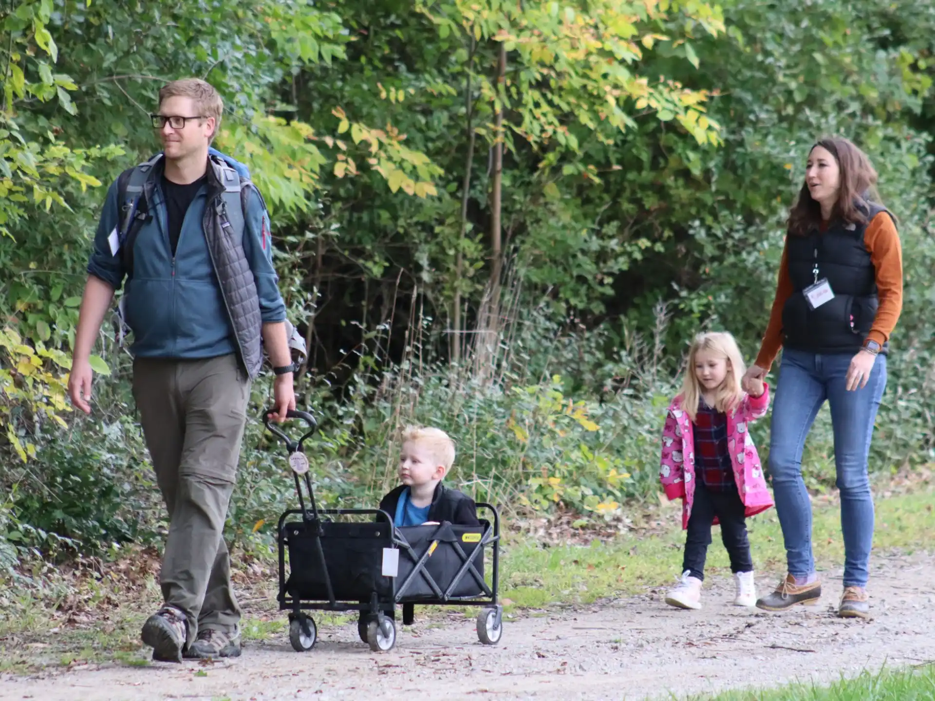 a group of people walking with a baby in a stroller