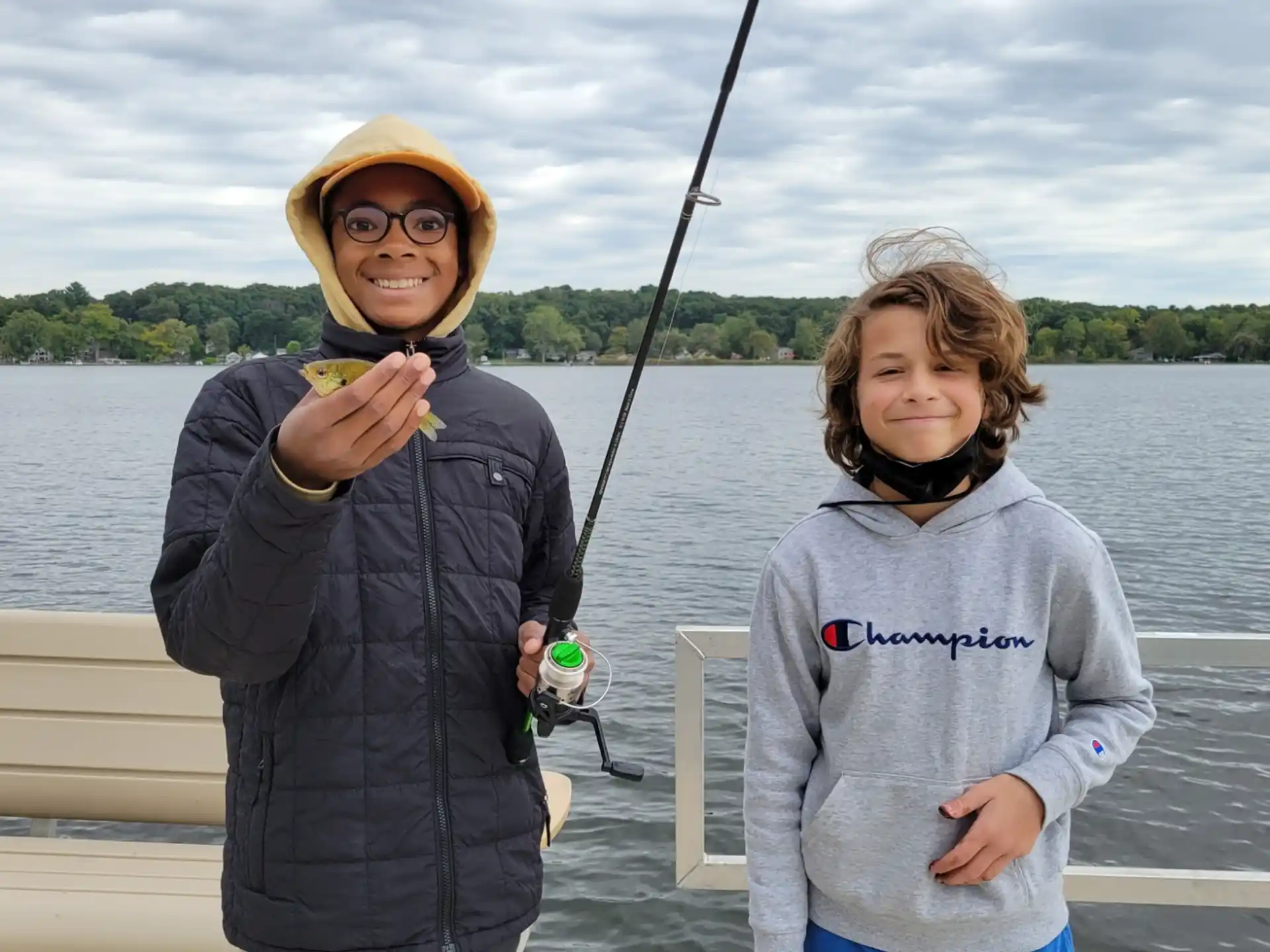 a person and a girl on a boat holding a fishing pole