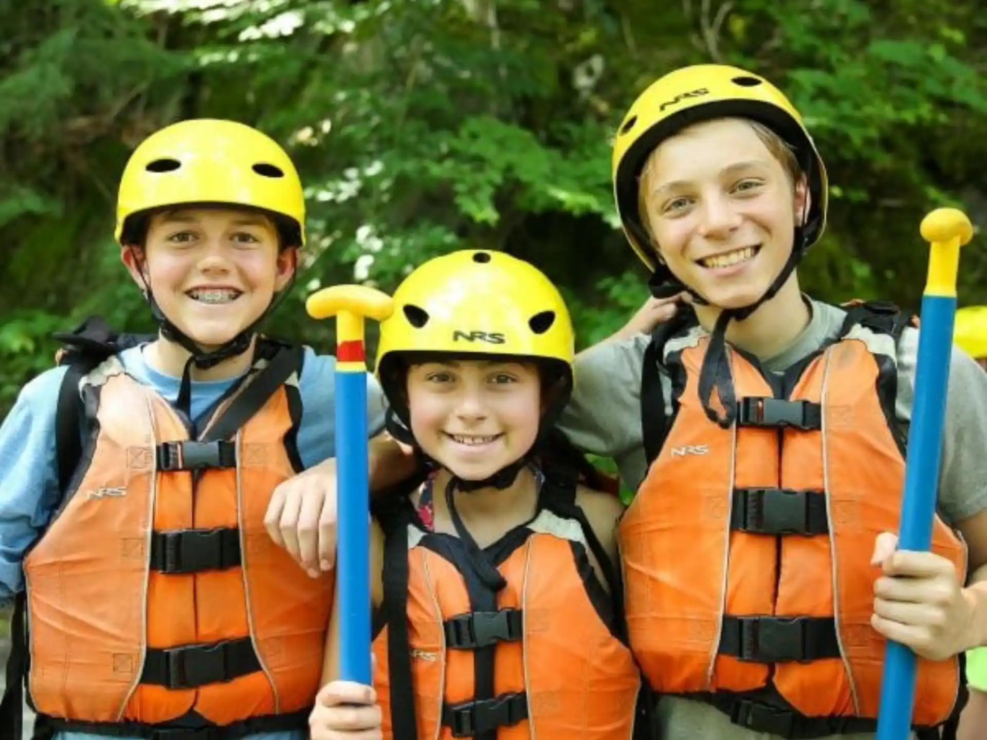 a group of people wearing helmets and holding bats