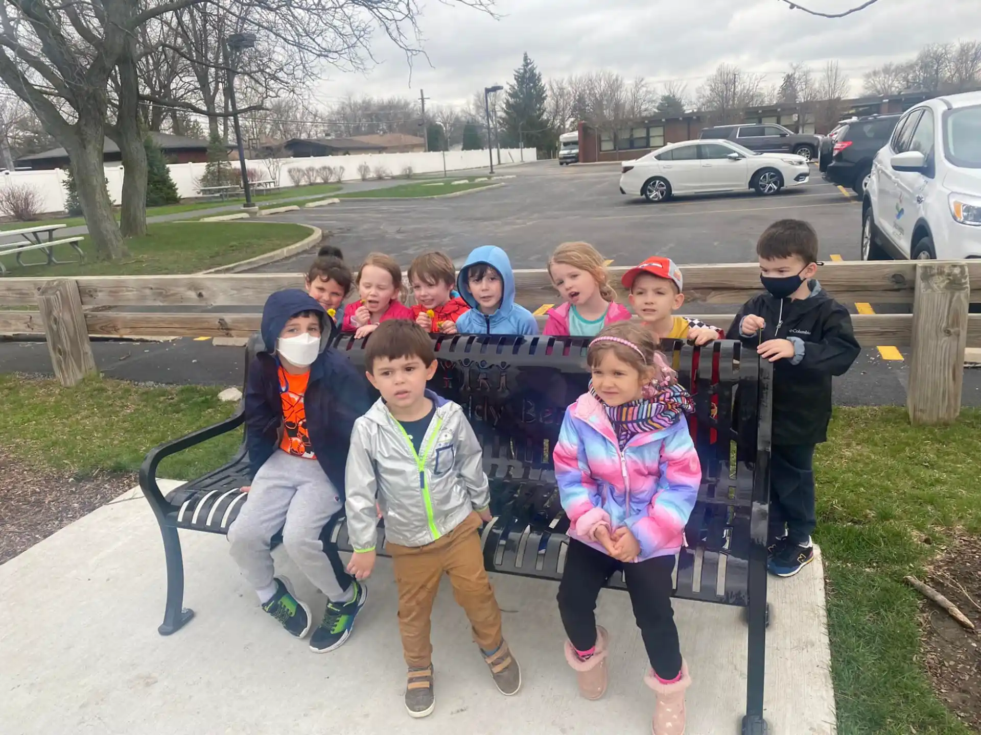 a group of children posing for a photo on a bench