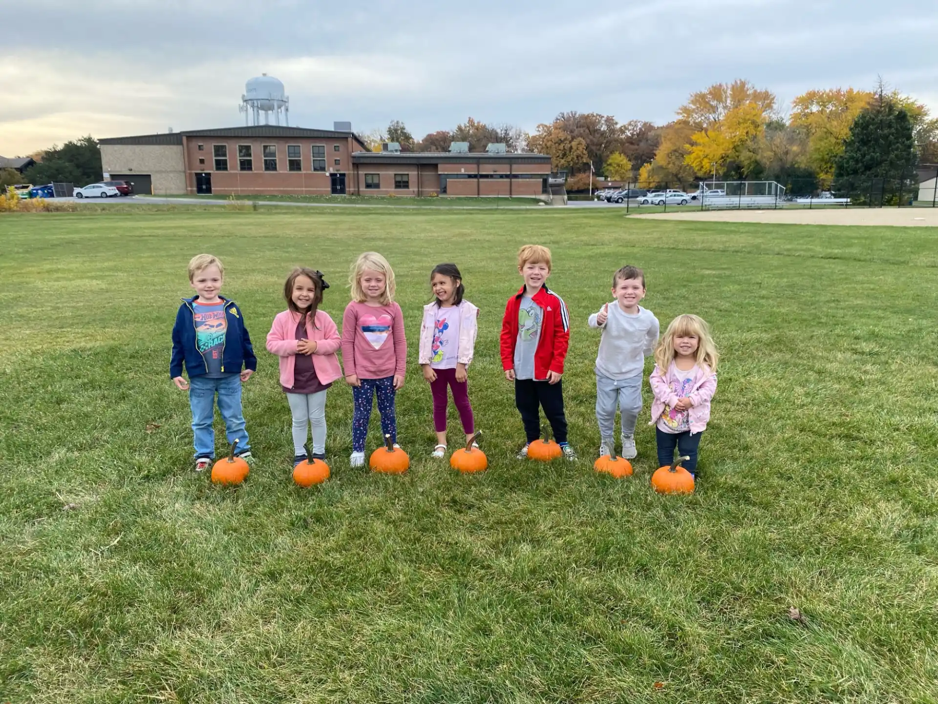a group of children standing on a field with balls