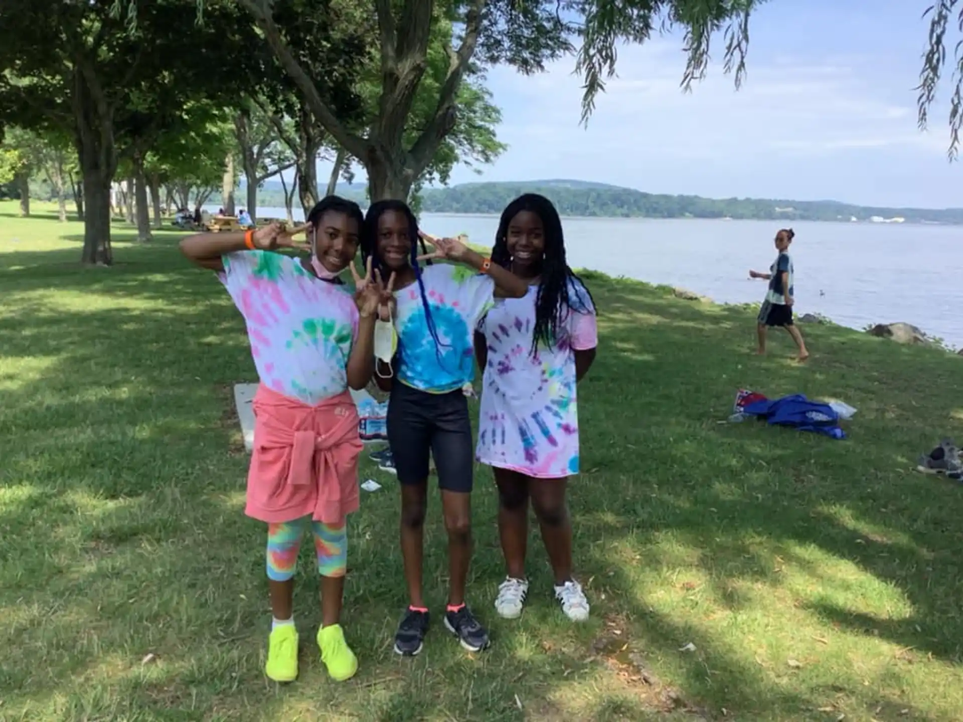 a group of people posing for a photo in front of a body of water