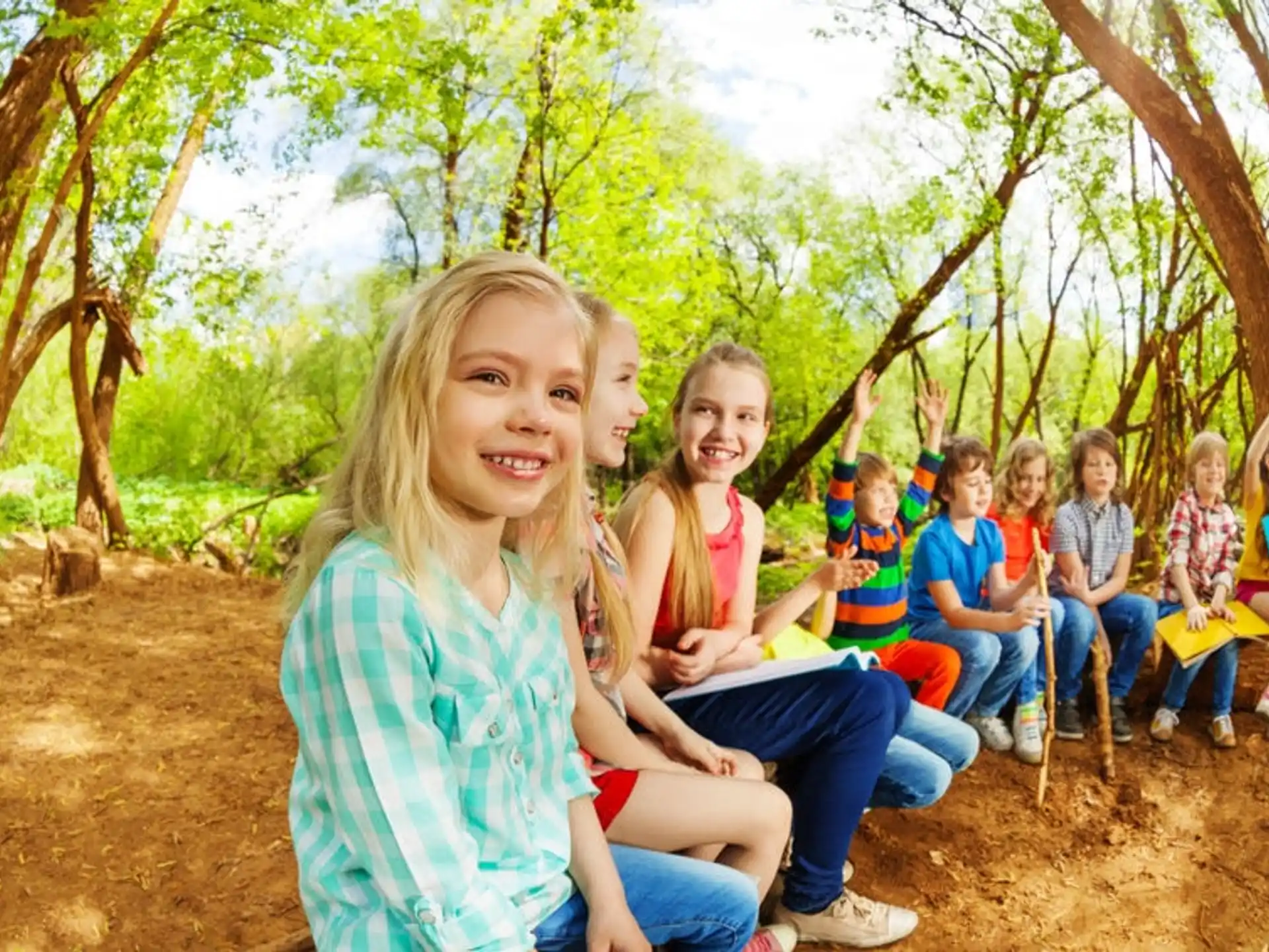a group of children sitting on a bench in a park