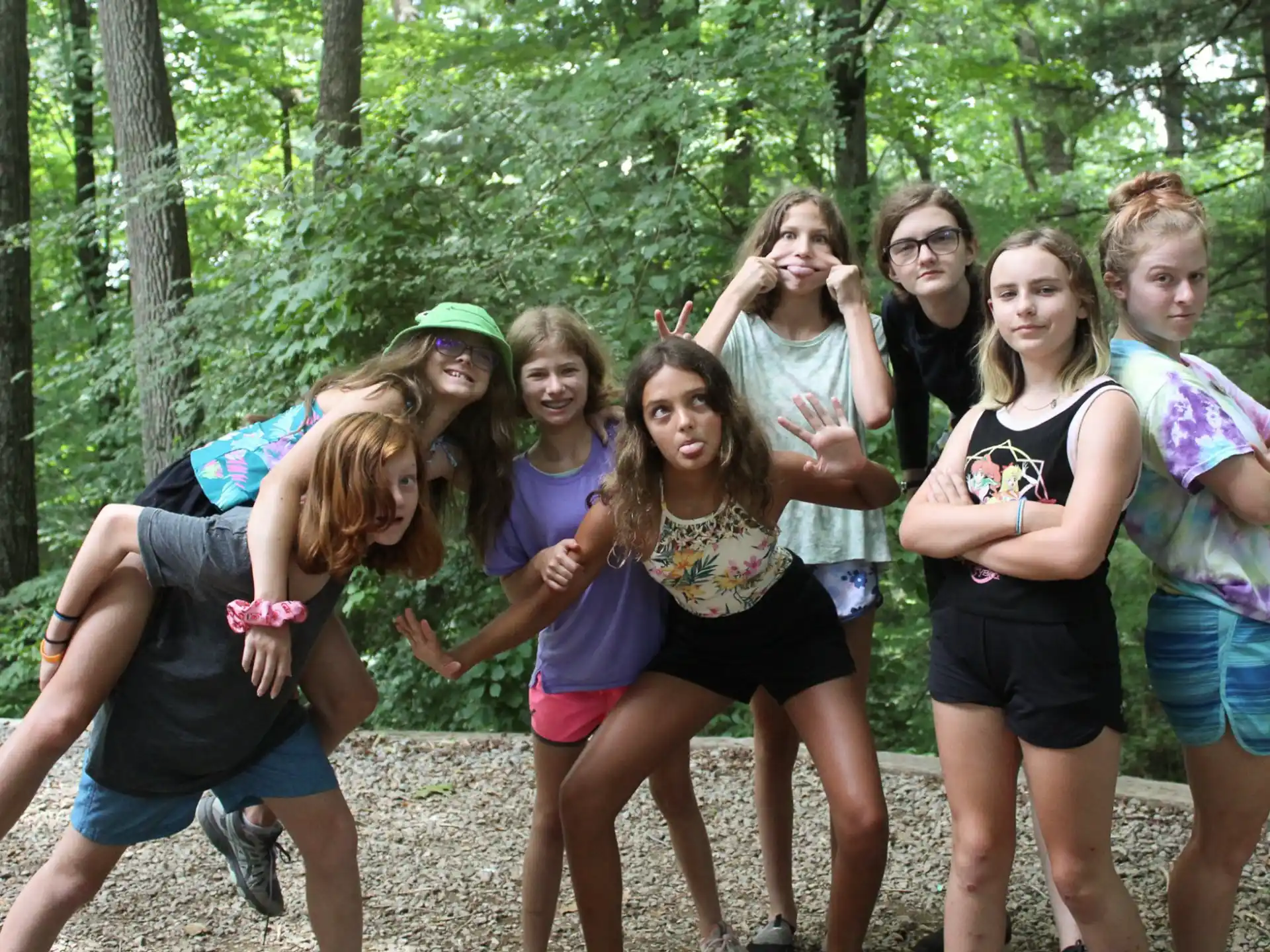a group of girls jumping in the air in the woods