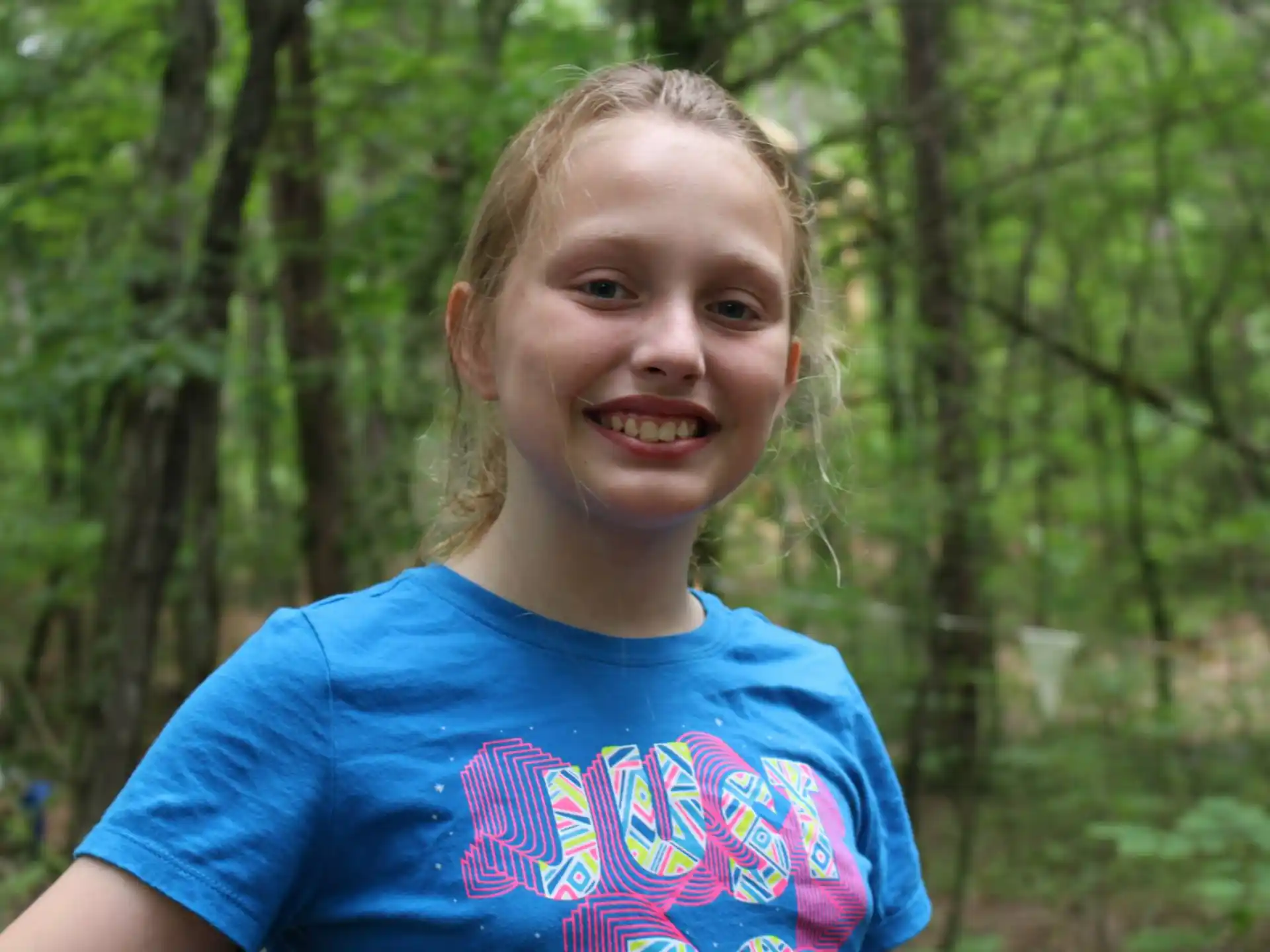 a girl smiling in the woods