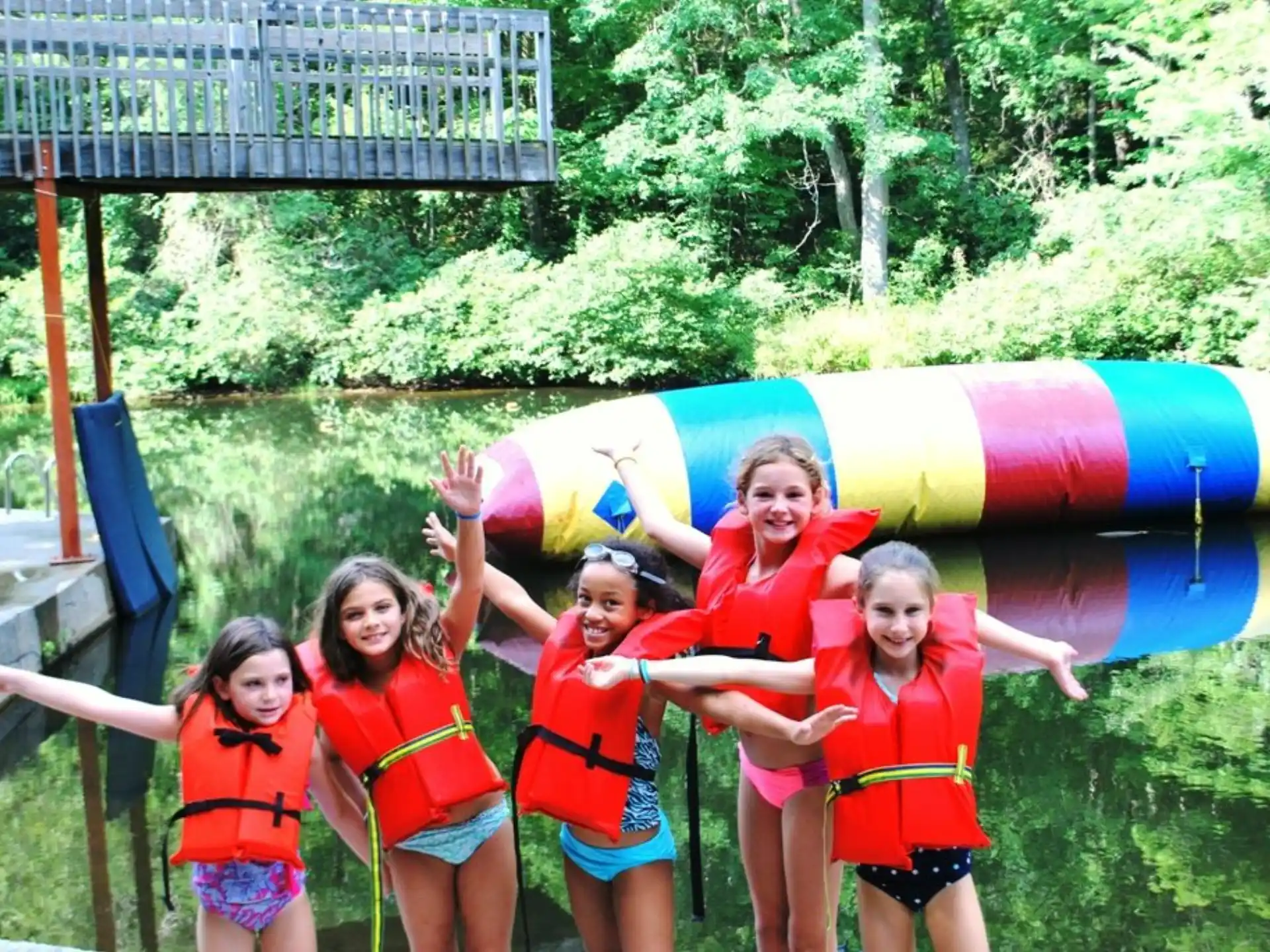a group of girls in life jackets posing for a photo