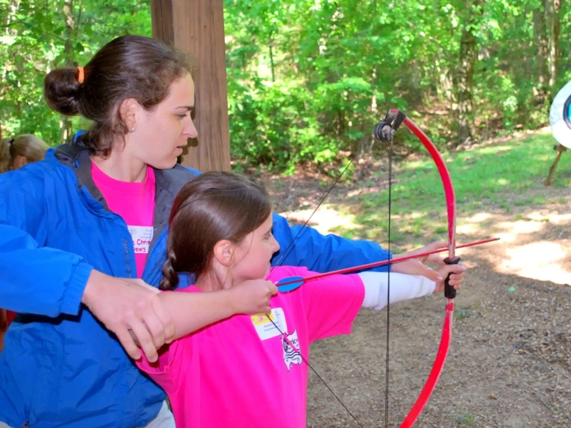 a person helping a child with a bow