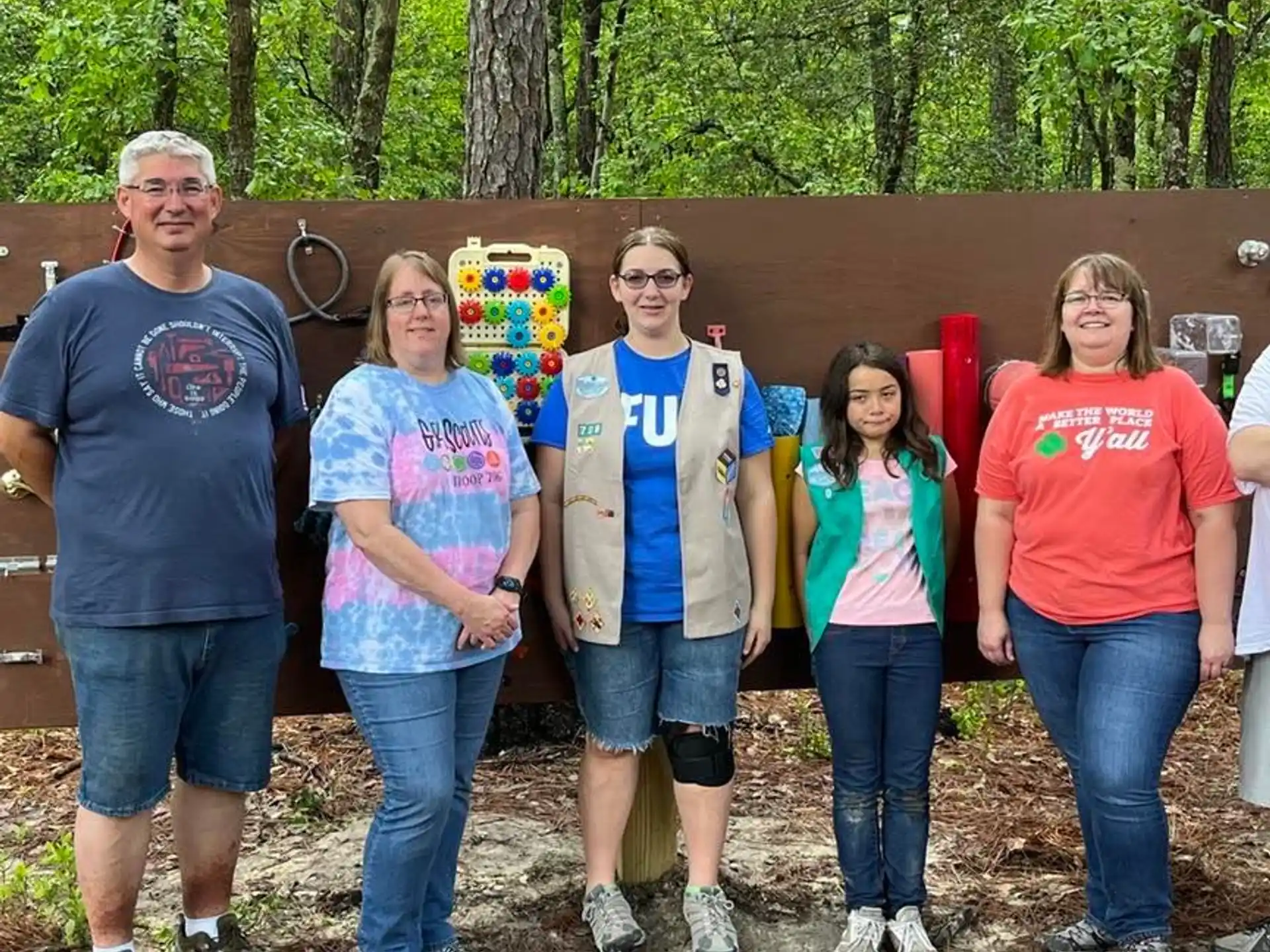 a group of people standing in front of a wood structure