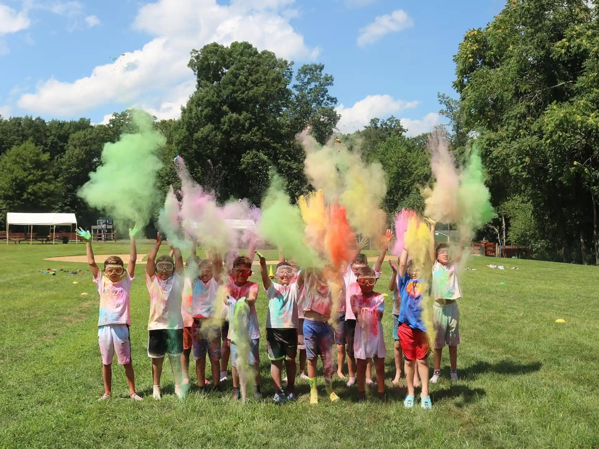 a group of children posing for a photo in front of a large fire