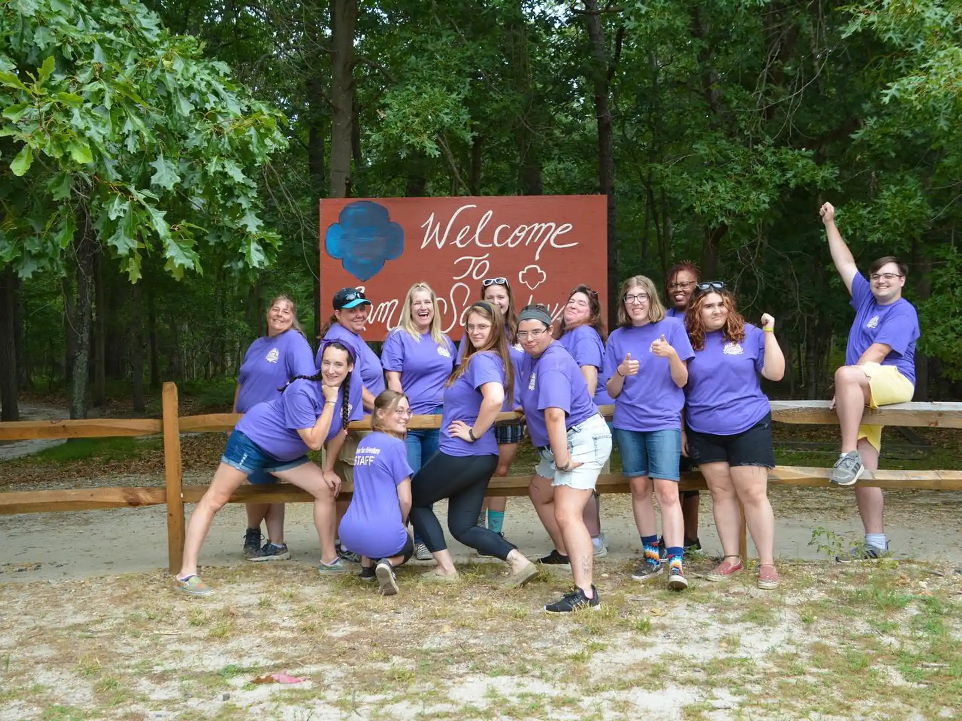 a group of people posing for a photo in front of a sign