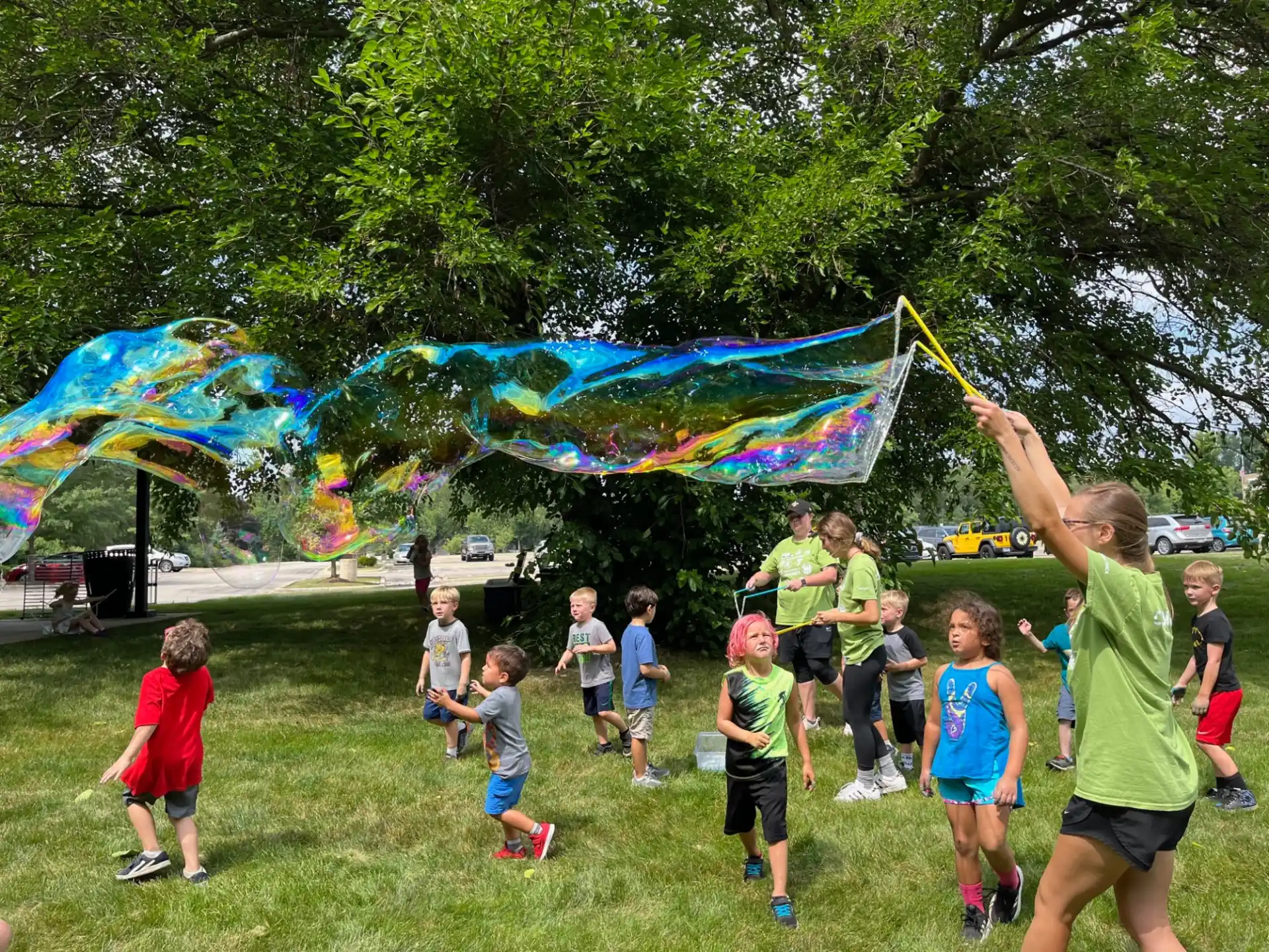 a group of kids playing with a large colorful bubble