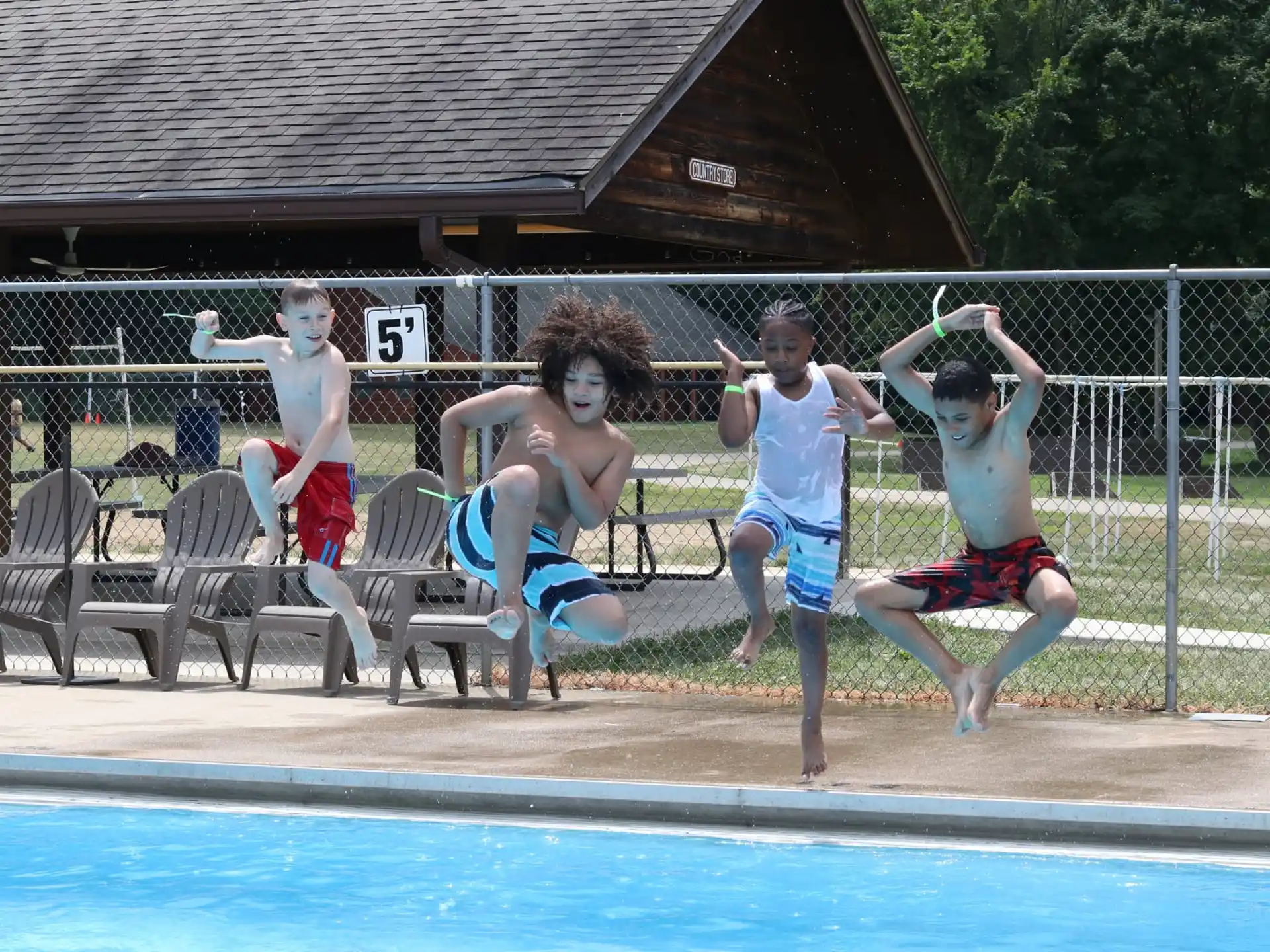 a group of kids jumping into a pool