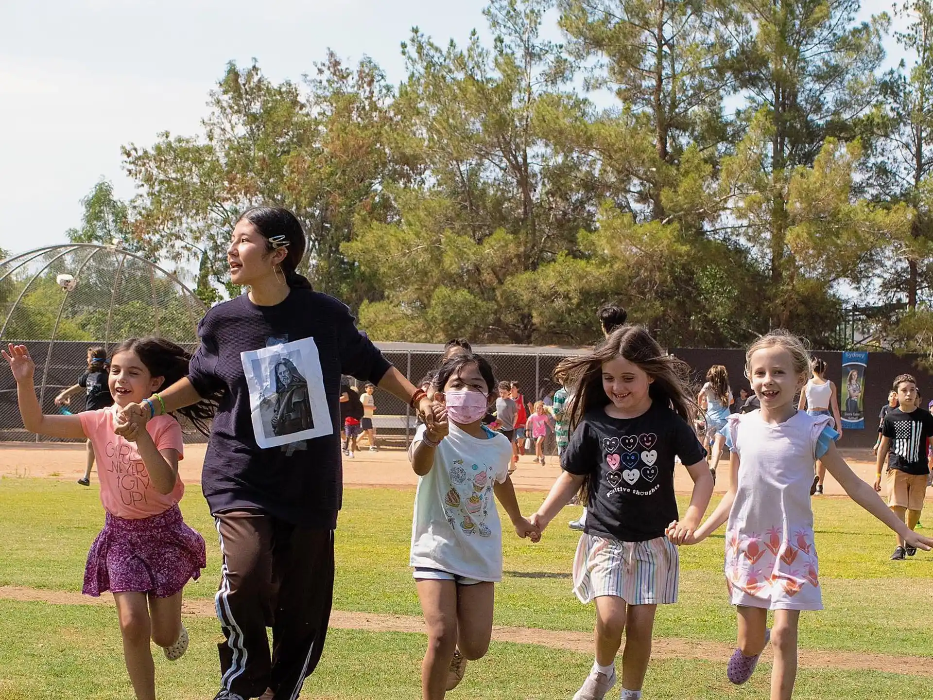 a group of children running on a grass field