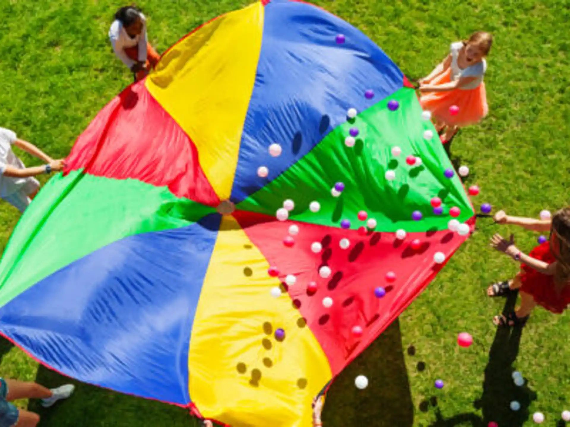 a group of people playing with colorful umbrellas