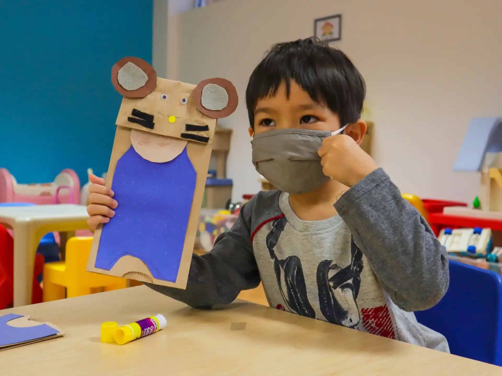 a boy holding a book and a toy bear
