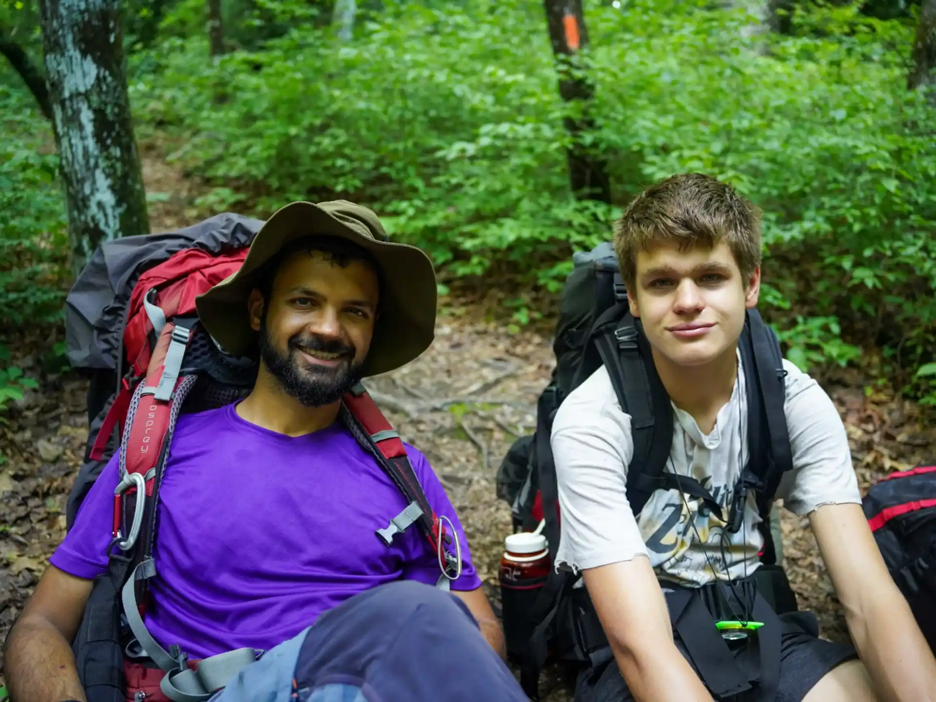 two men sitting on a rock