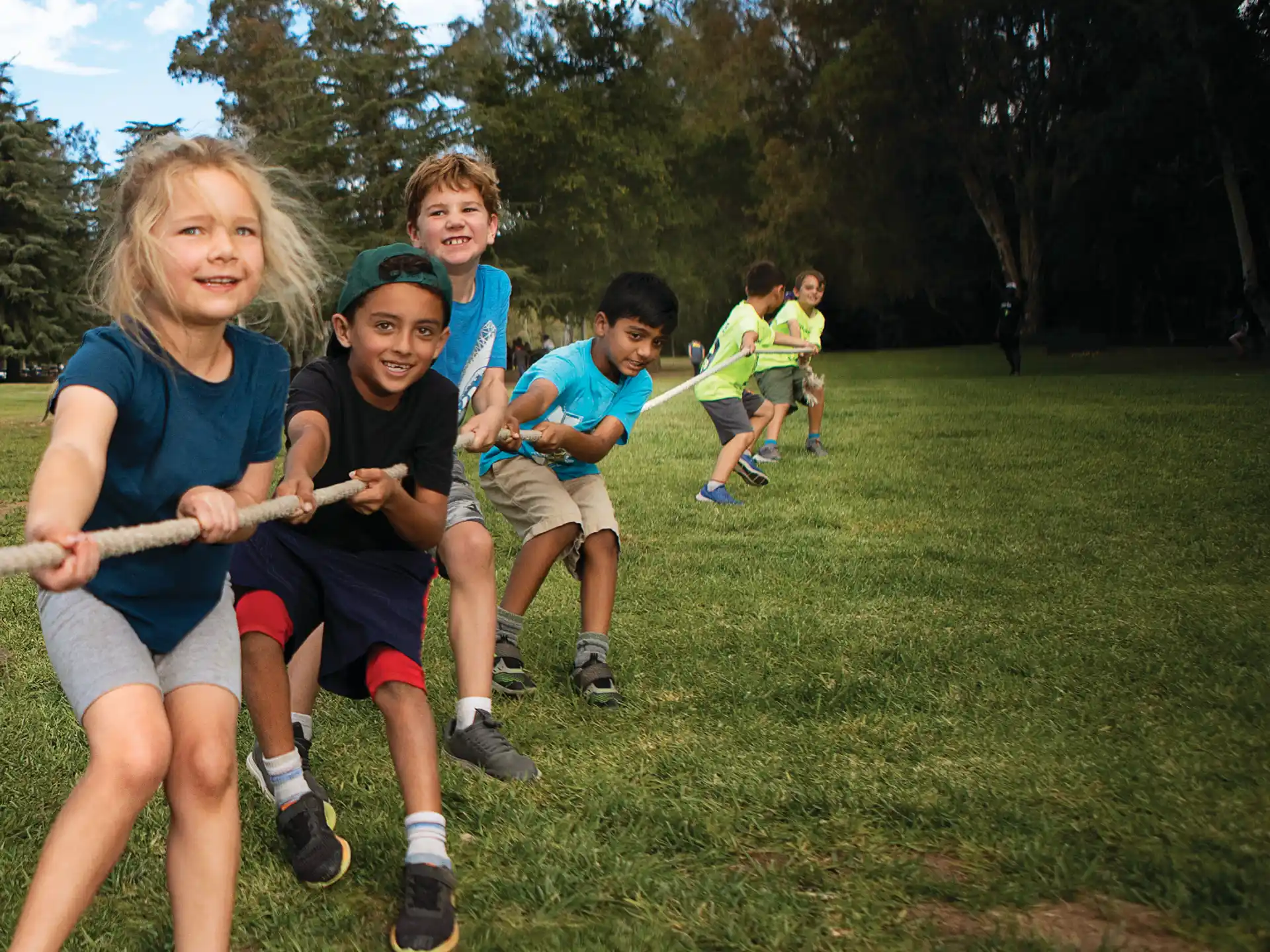 a group of kids running on a grass field