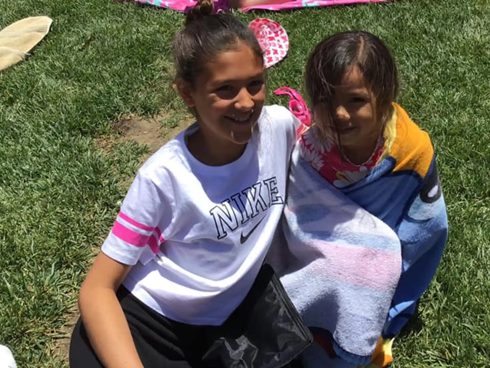 a person and a girl sitting on grass