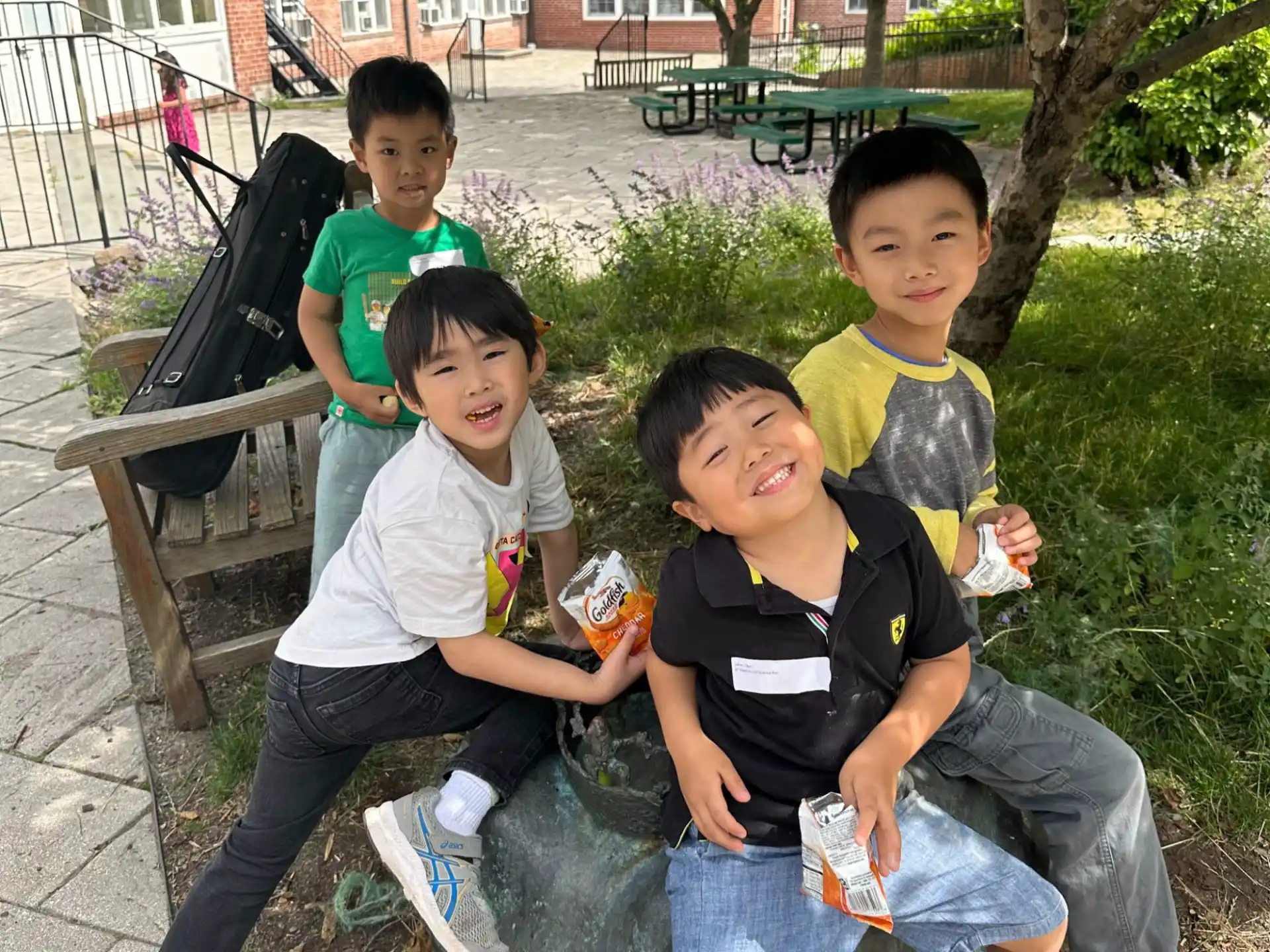 a group of boys sitting on a bench in a park