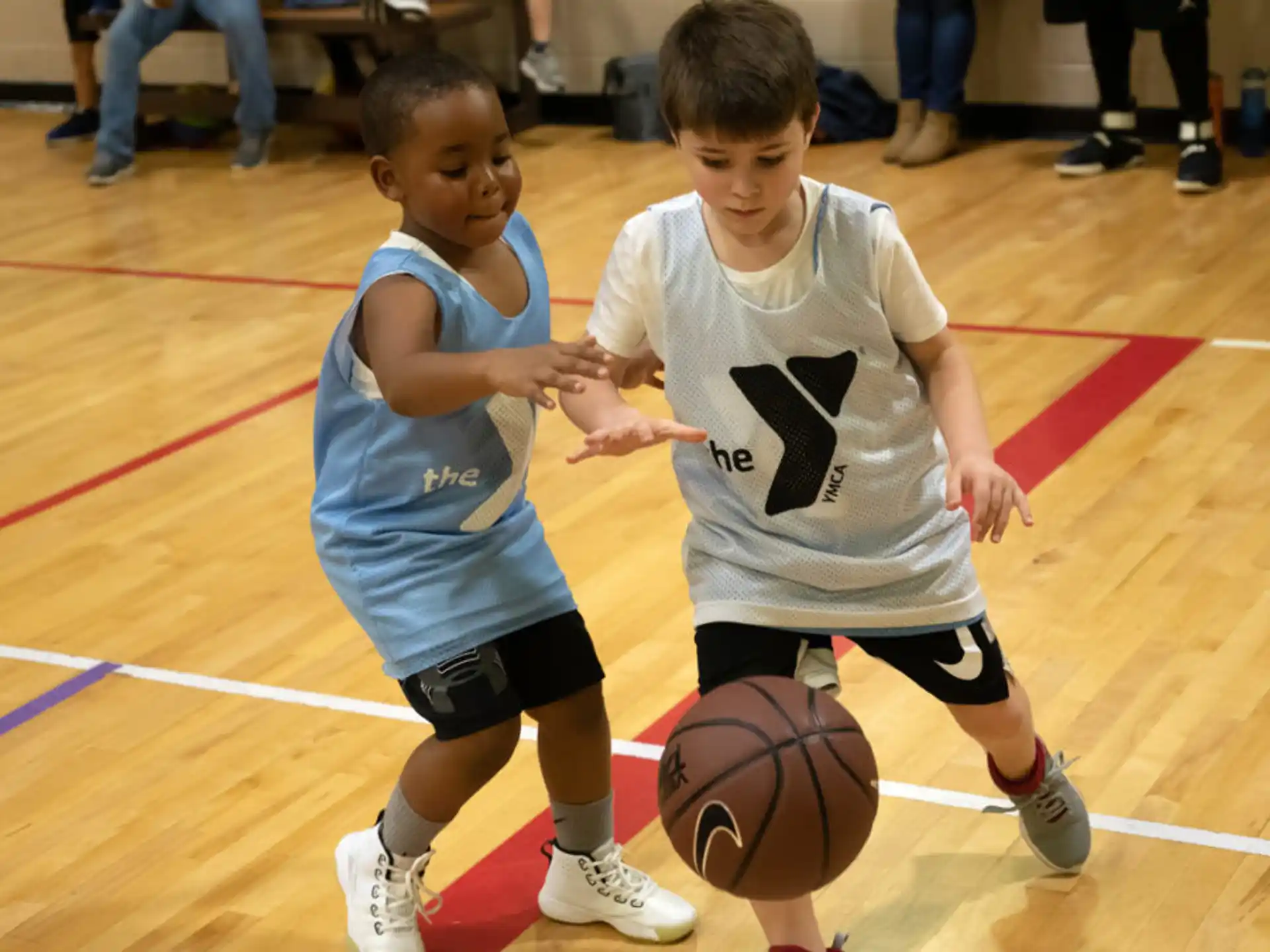 a couple of young boys playing basketball