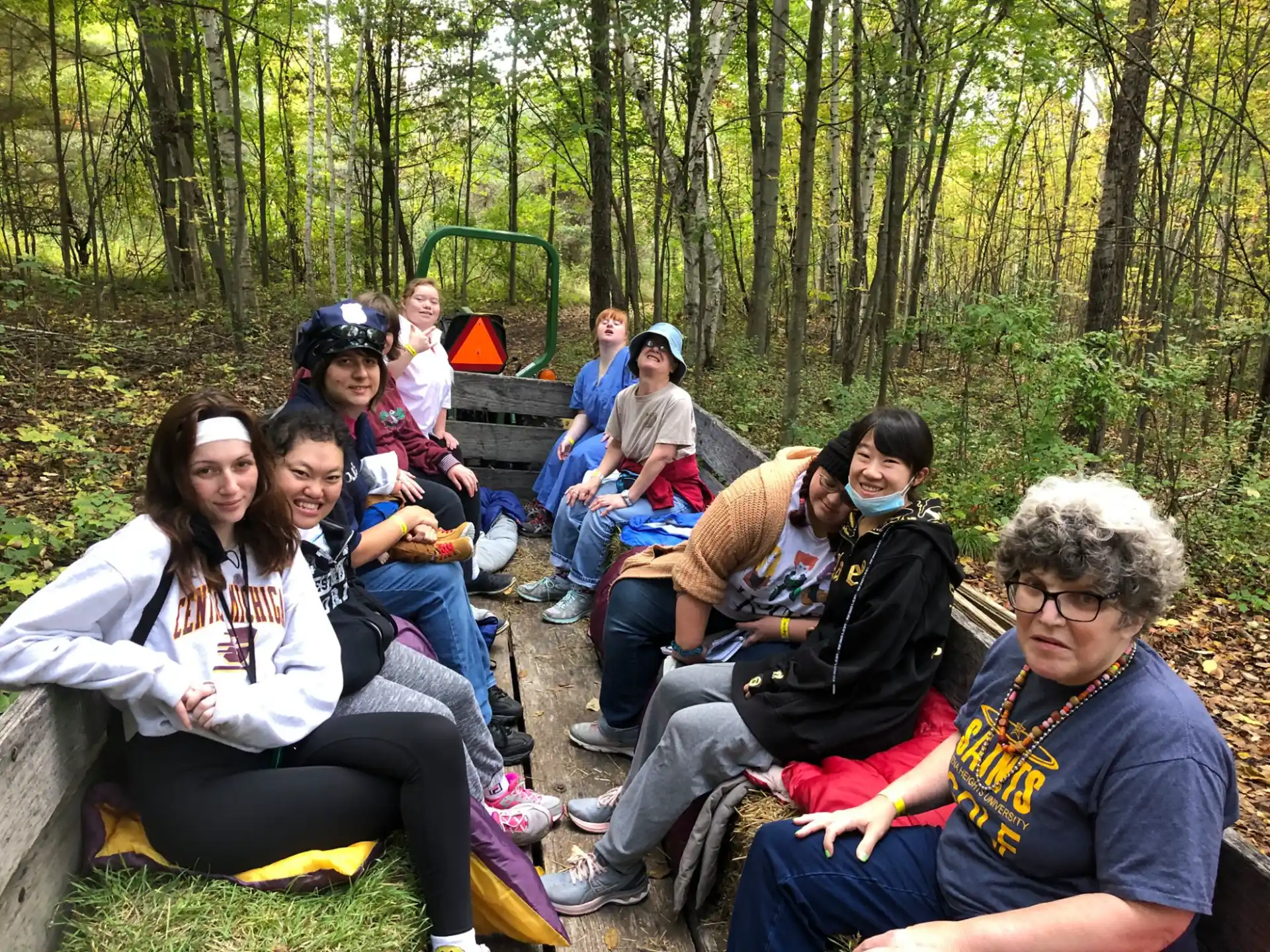 a group of people sitting on a bench in the woods
