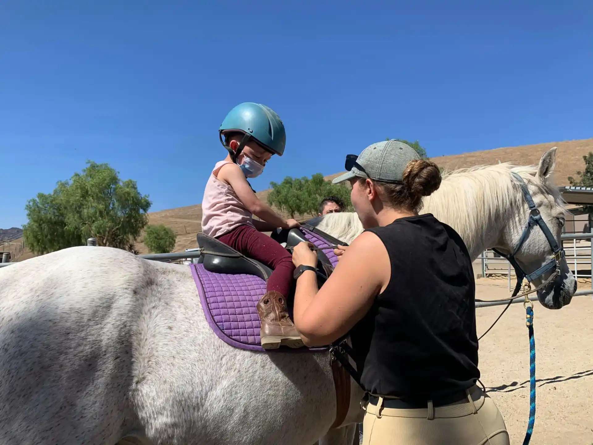 a person riding a horse with a child on the back