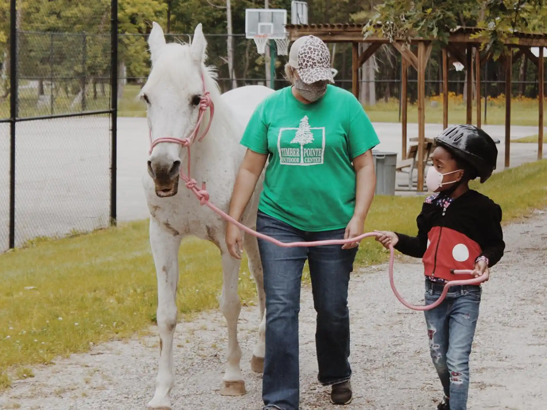 a person and a girl petting a horse