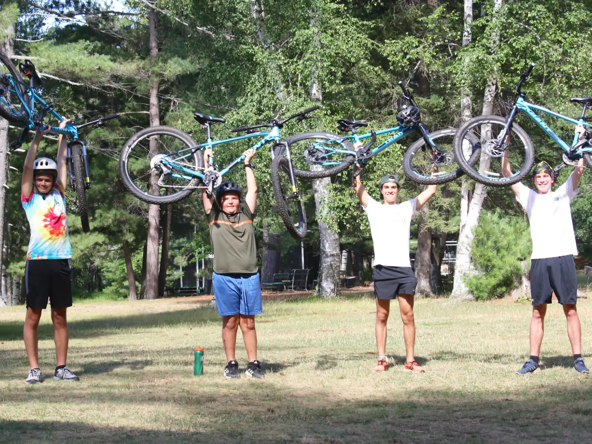 a group of people holding bicycles