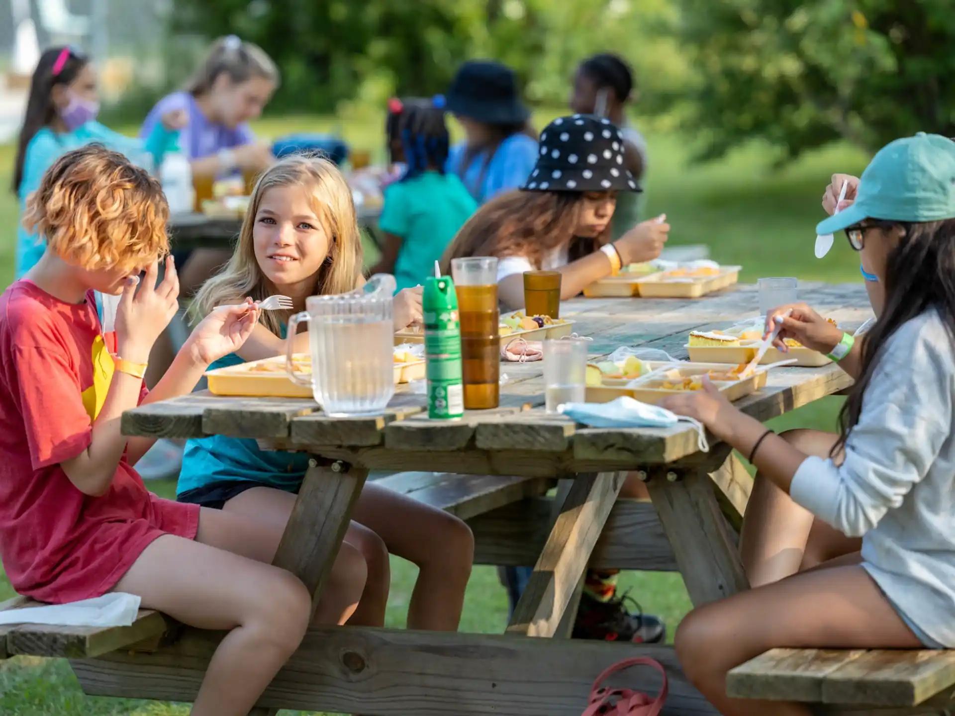 a group of people eating at a picnic table
