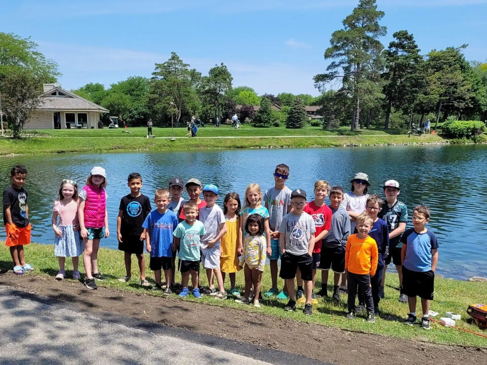 a group of people posing for a photo next to a body of water