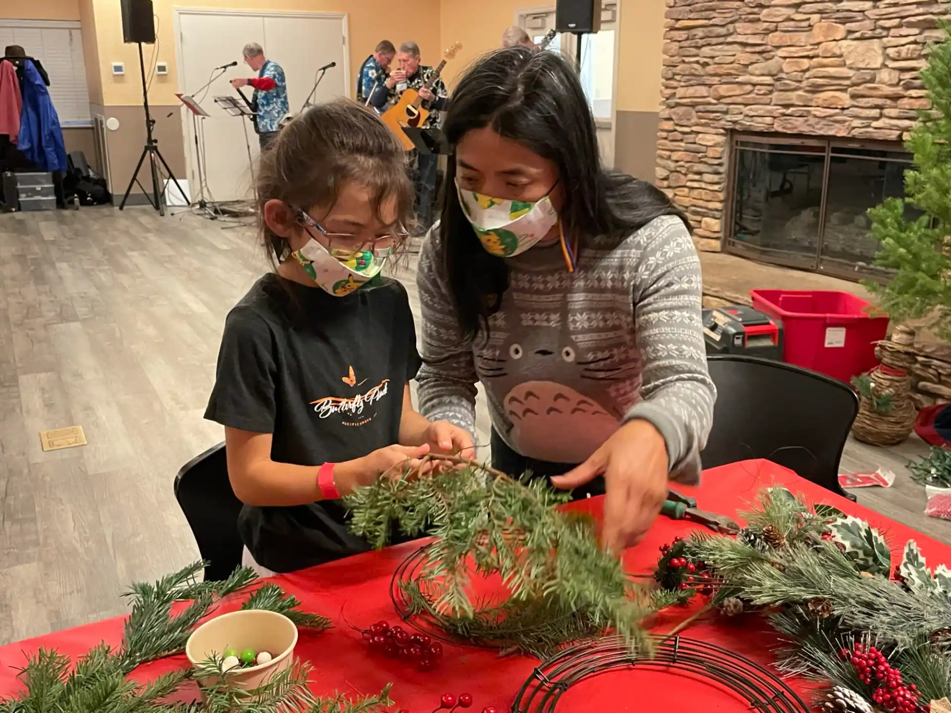 a person and a girl at a table with plants