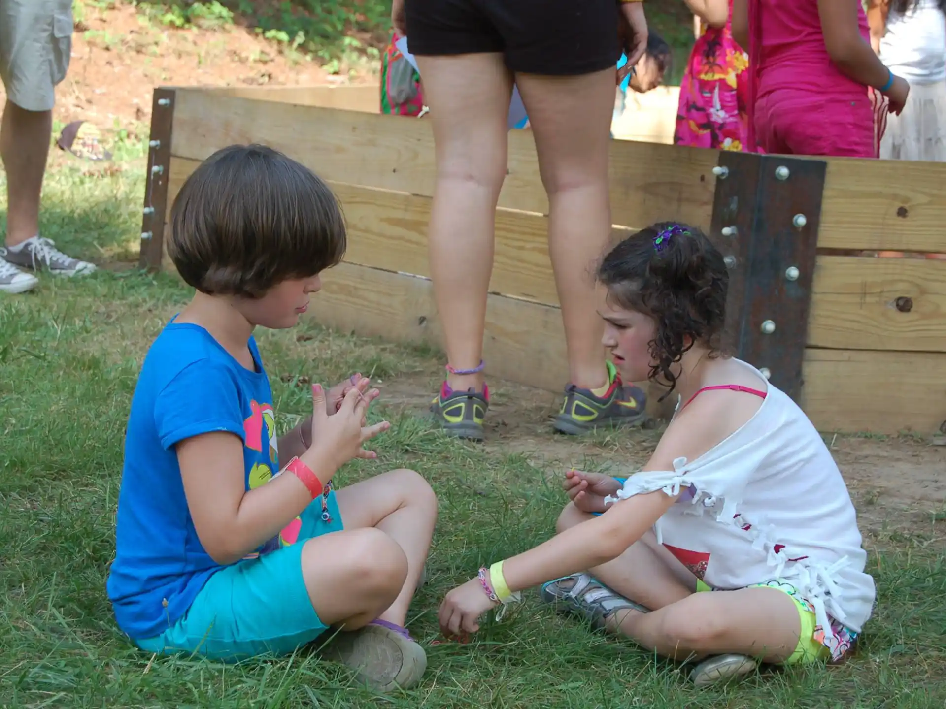 a couple of children sitting on grass