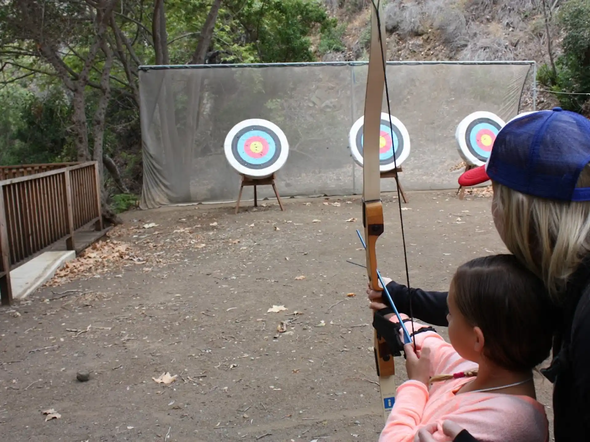 a person and a couple of kids holding a bow and arrow