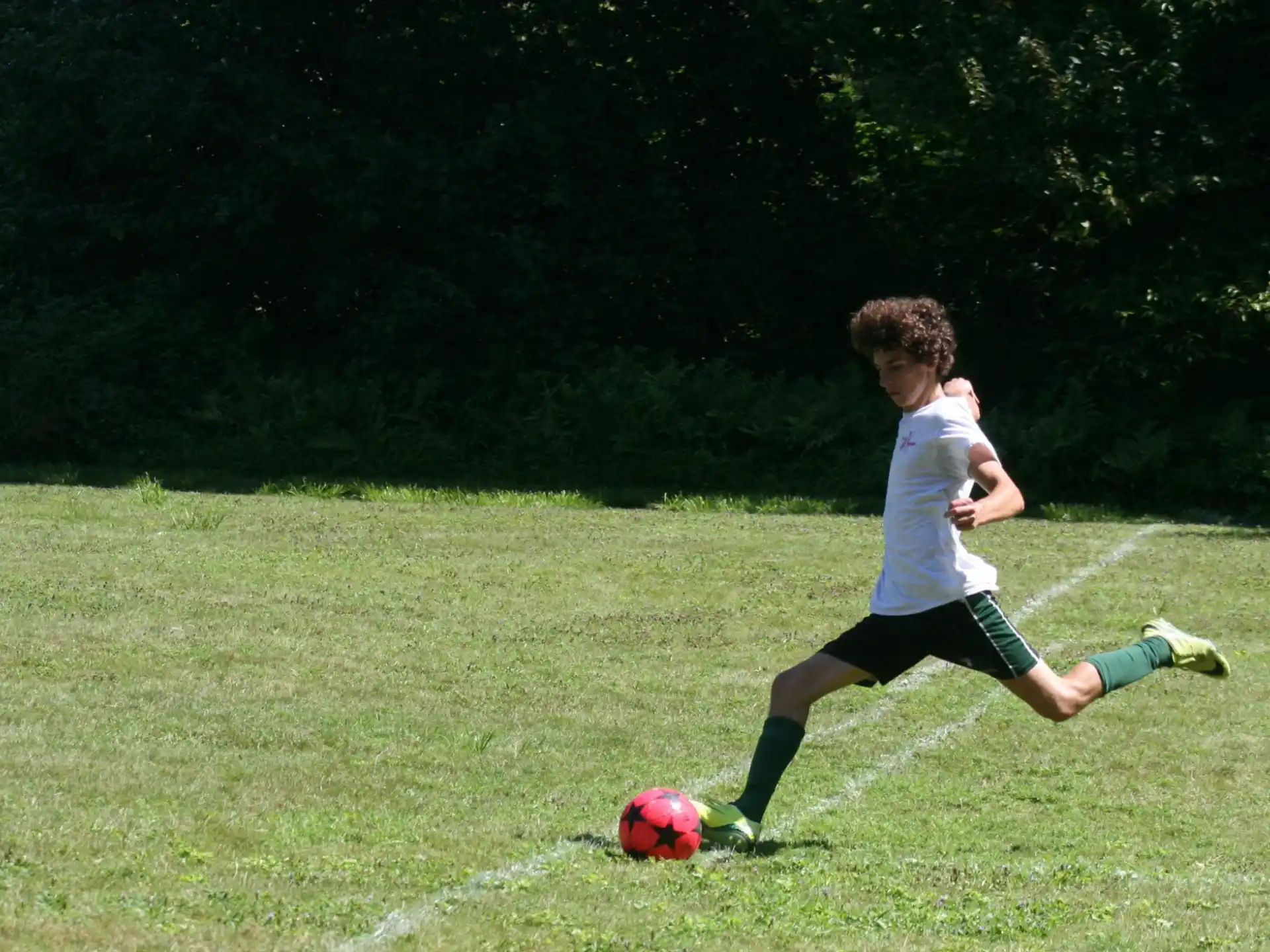 a boy kicking a football ball