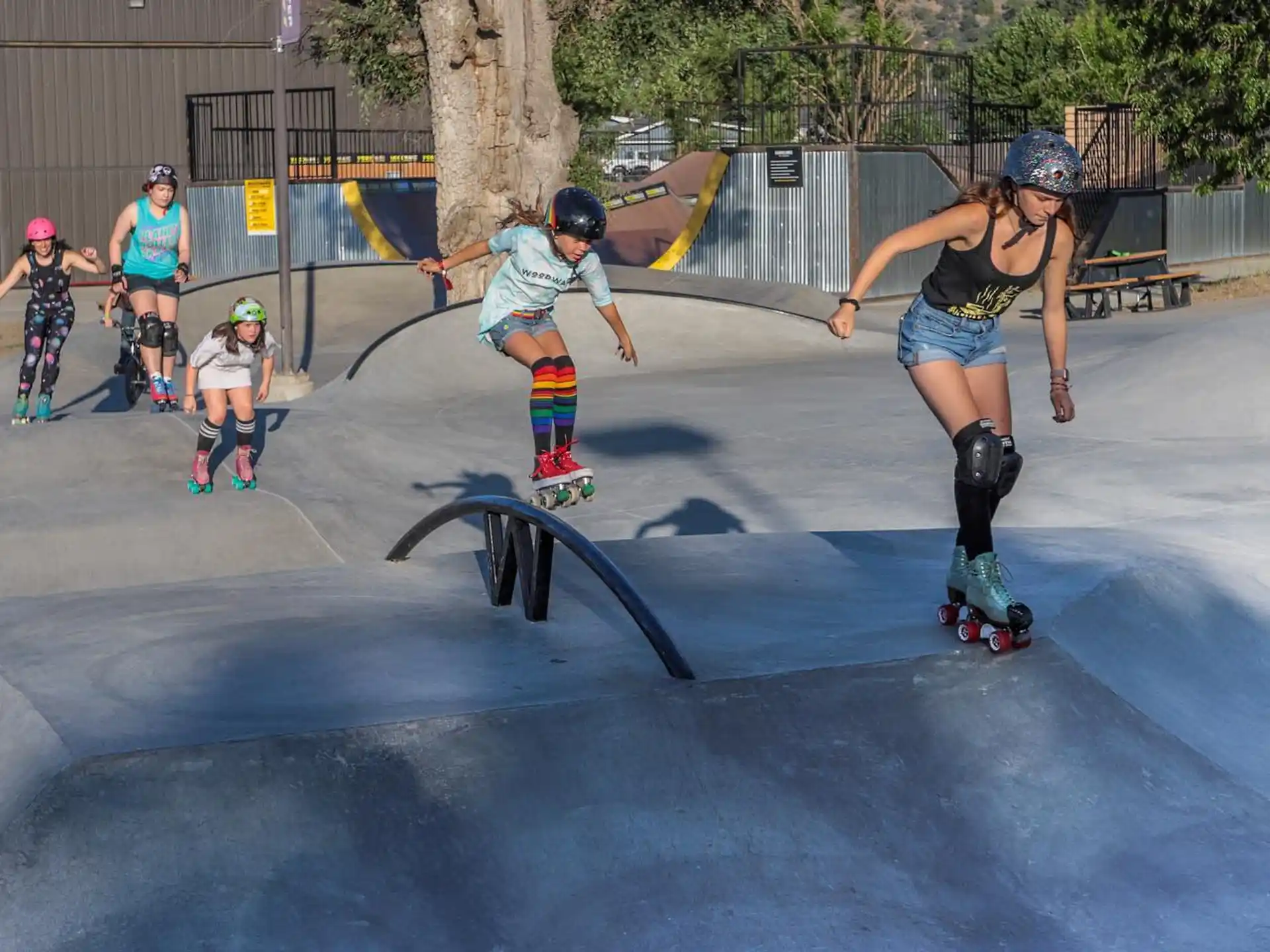 a group of women rollerblading at a skate park