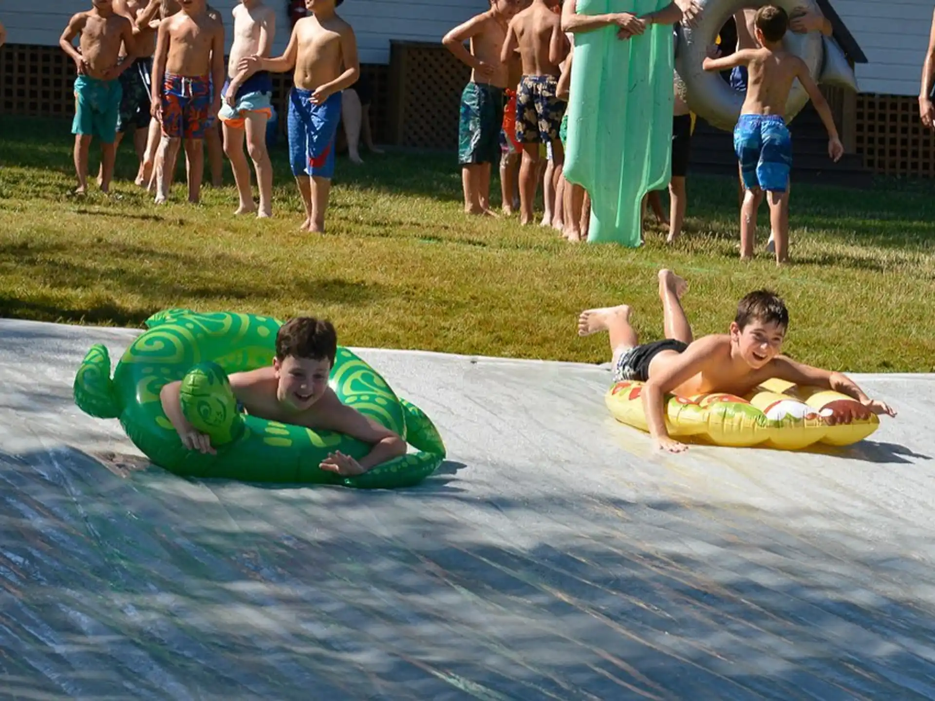 two boys lying on a mat in front of a group of people