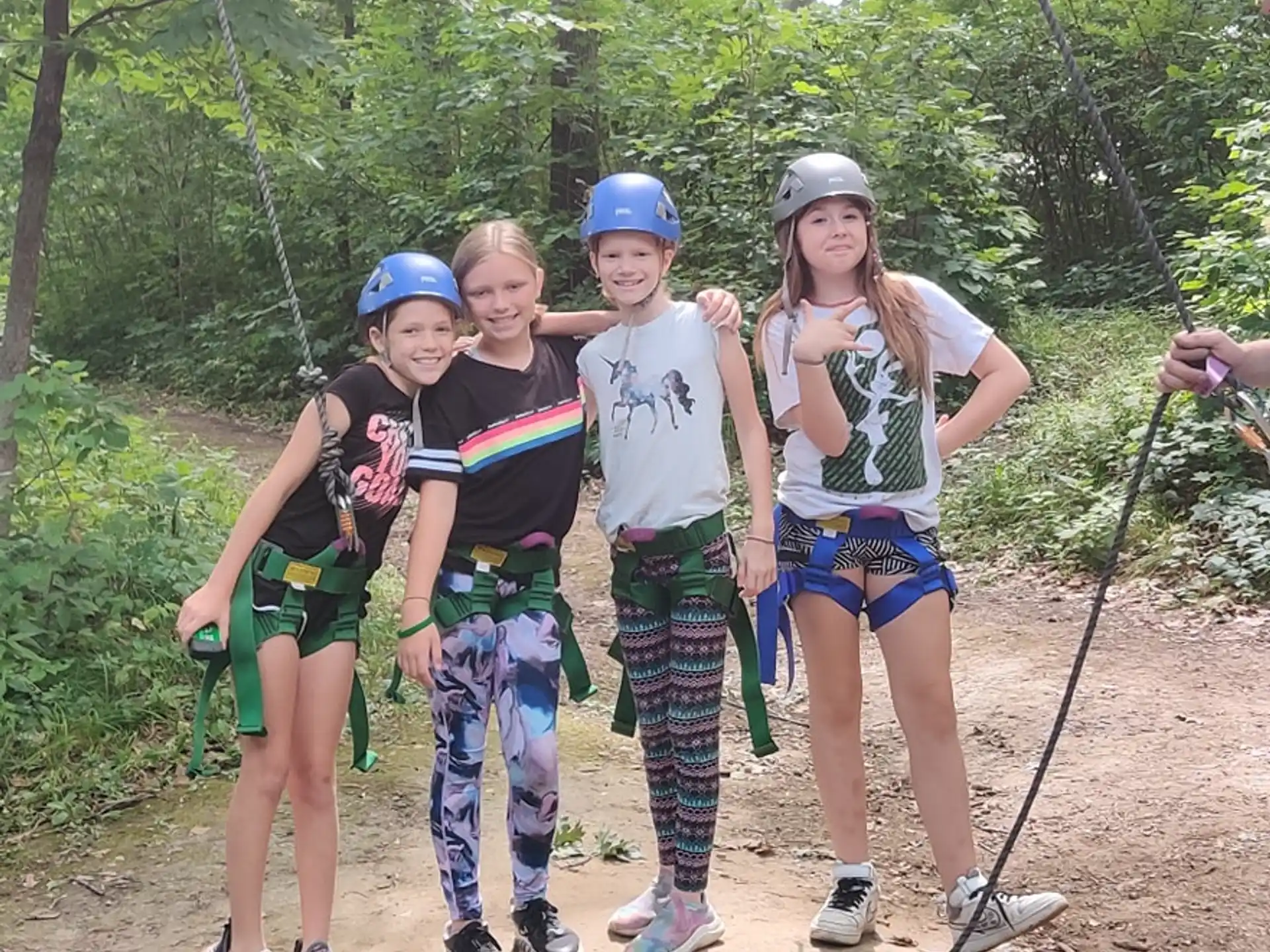 a group of people wearing helmets and standing in the woods