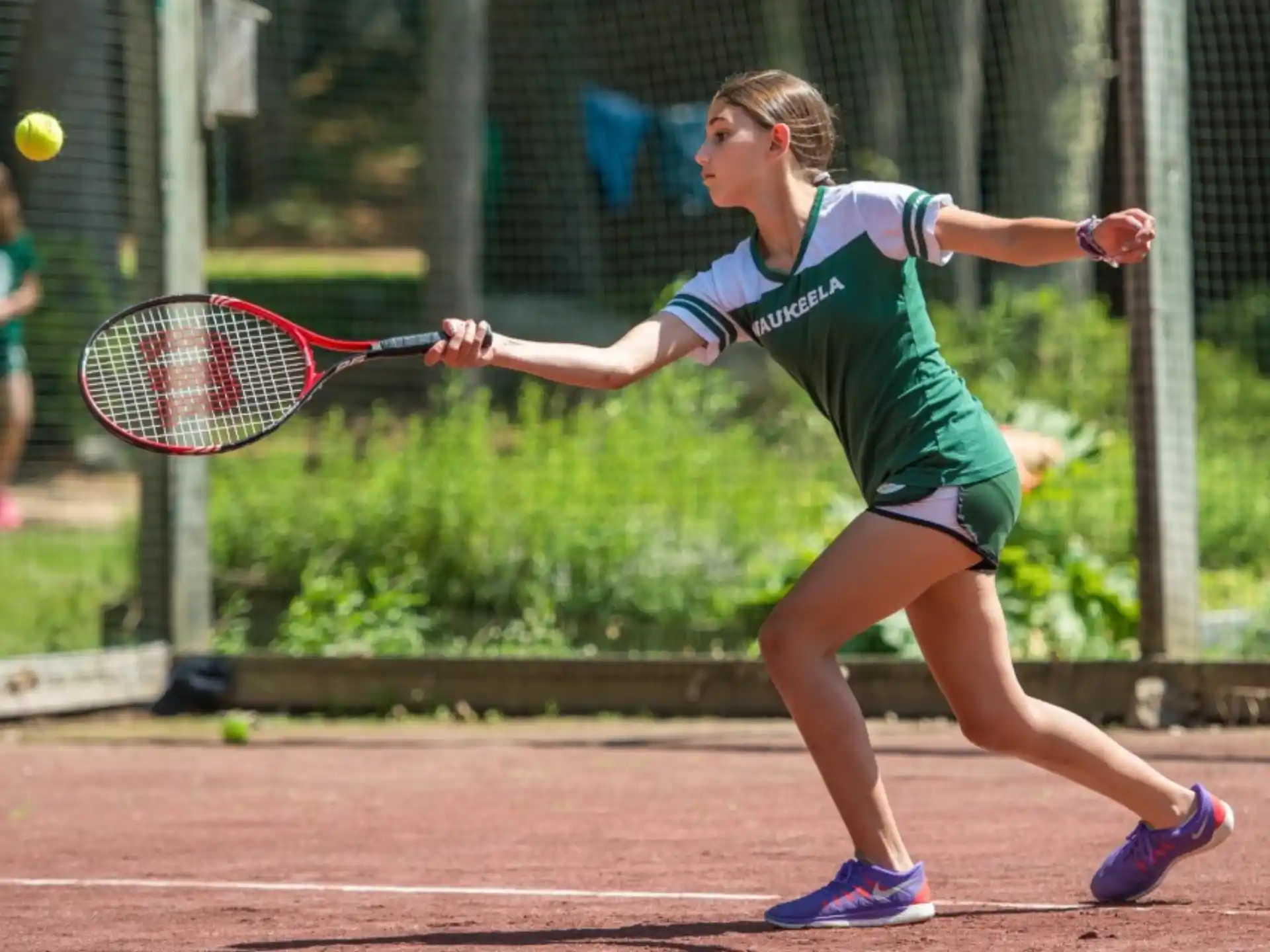 a woman hitting a ball with a tennis racket