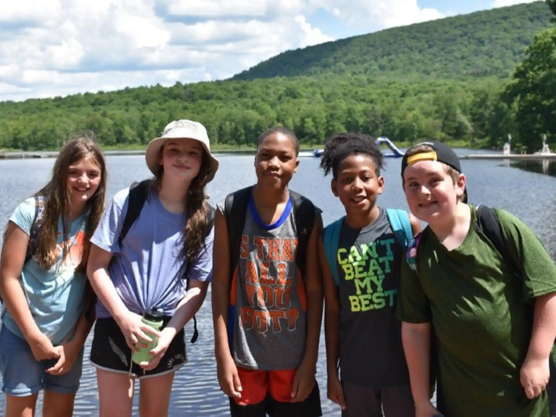 a group of people posing for a photo in front of a lake