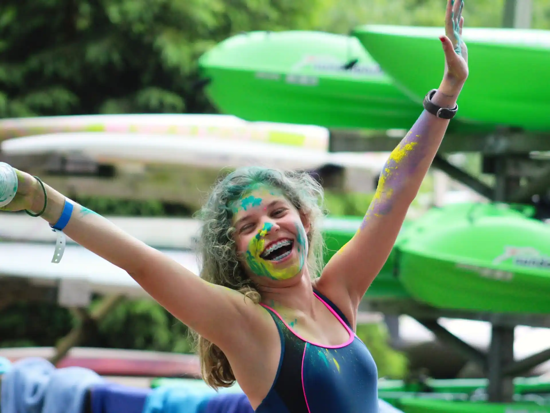 a woman with green paint on her face and a green object in her hand