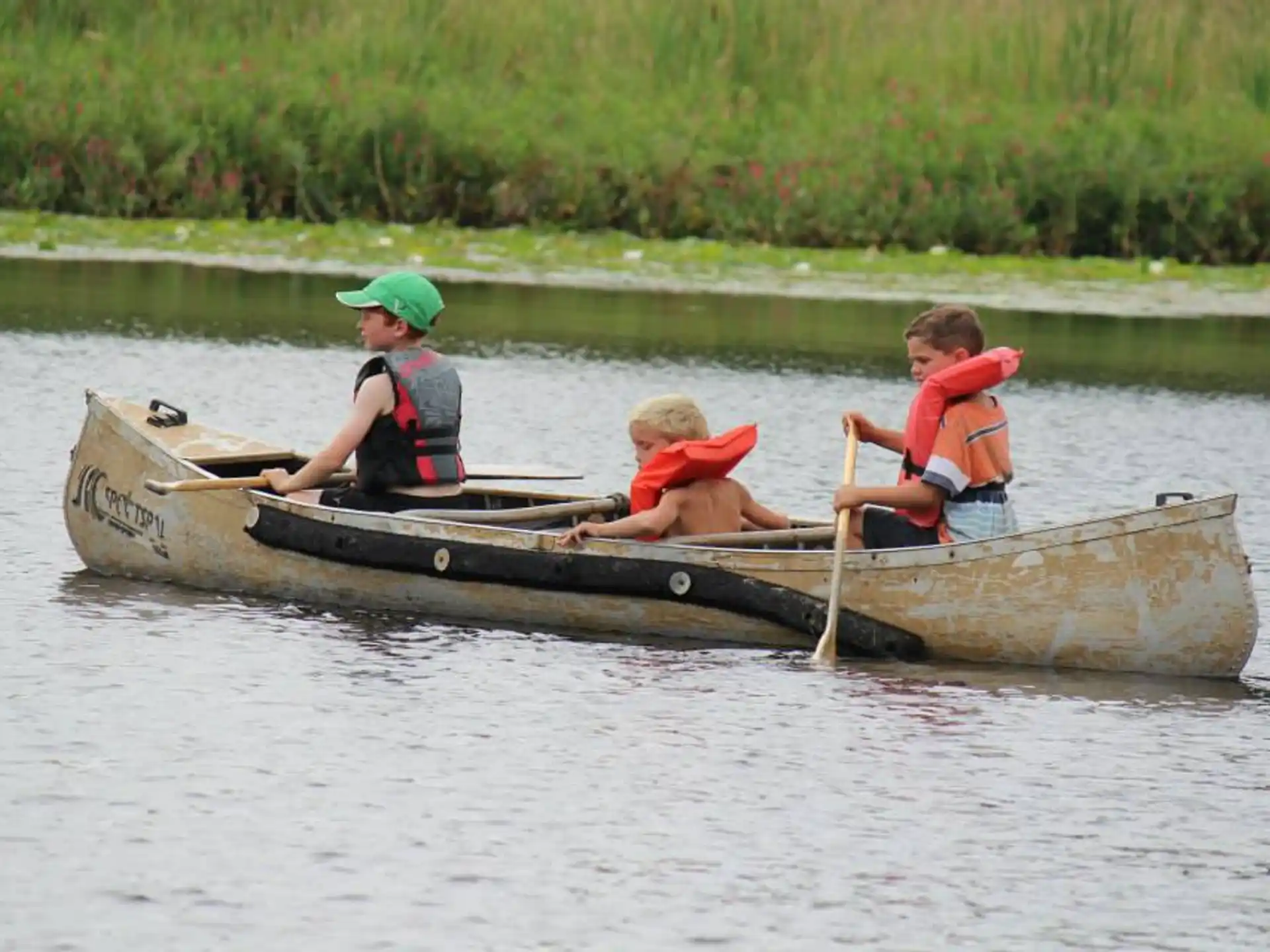 a group of kids in a canoe