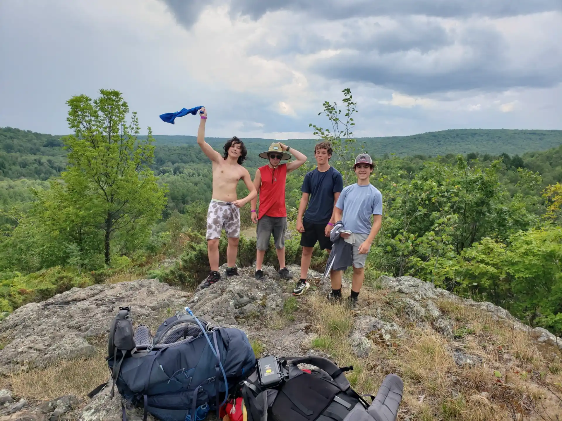 a group of people standing on a hill with a blue object in the air