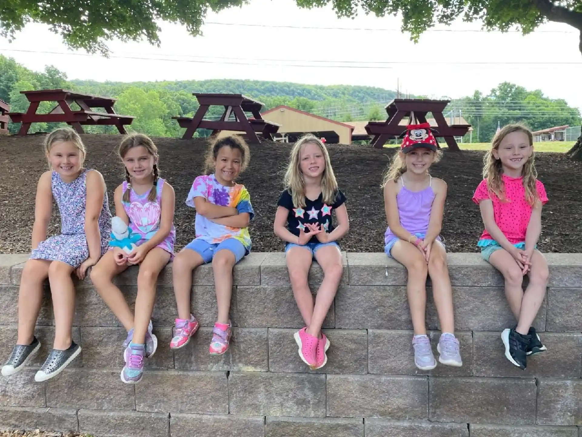 a group of girls sitting on a stone bench