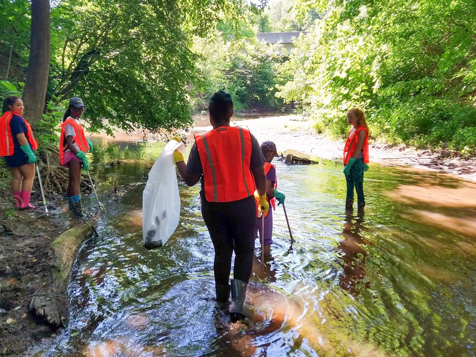 a group of people walking in a stream